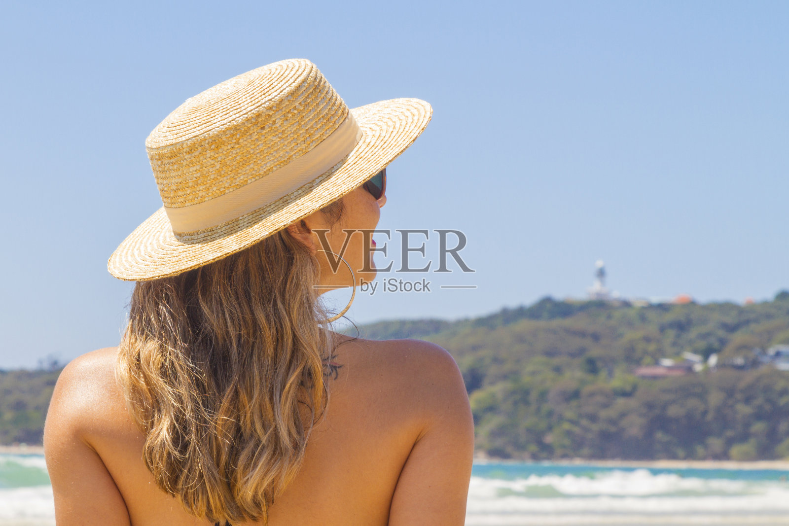 年轻的夏天女人戴着帽子和太阳镜在海滩上照片摄影图片