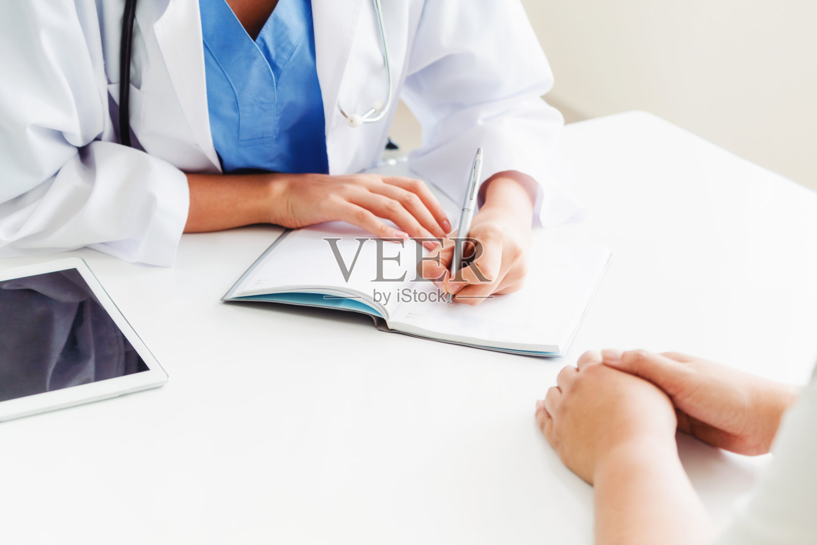 女医生和女病人在医院的办公室照片摄影图片