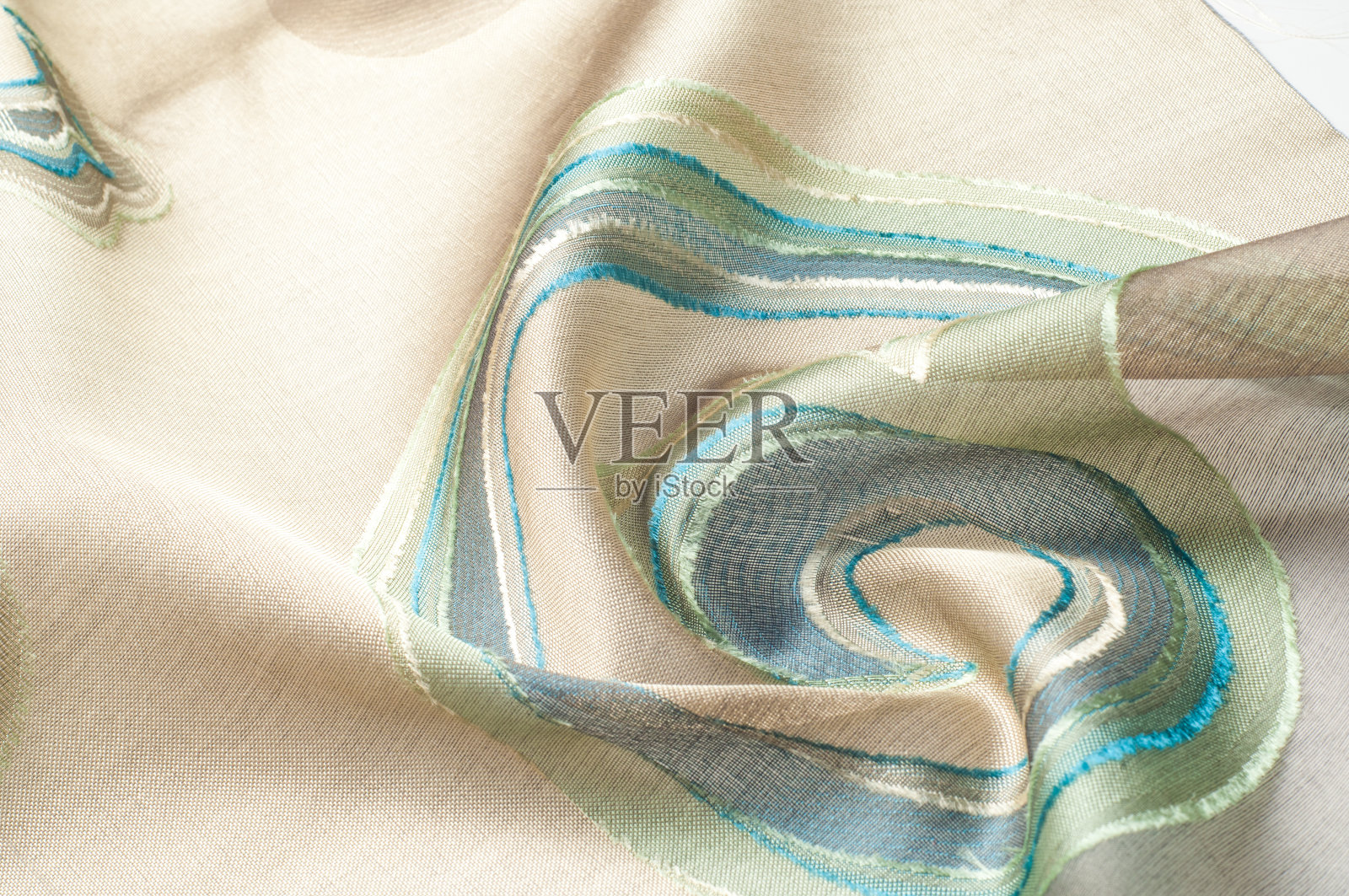 质地、背景、模式。丝绸织物。在一张黑色背景的贺卡上，画上绿色和蓝色的圆圈。丝绸围巾、披肩。假期。照片摄影图片