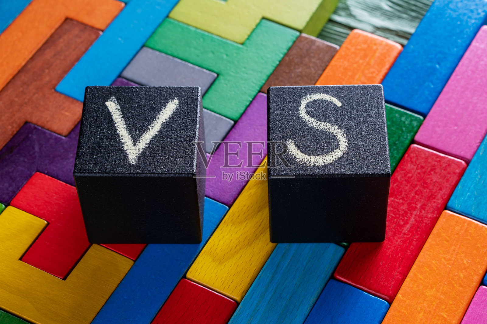 字母VS在彩色的木质背景与复制空间。选择的概念。字母VS的黑色方块。照片摄影图片