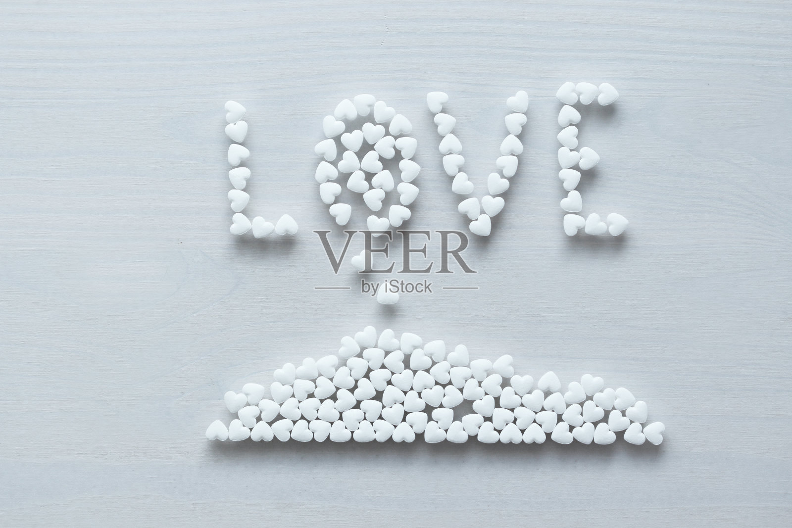 “爱”这个词是用白色的心划线或写在白色的背景上。使用复制空间进行设计。俯视图照片摄影图片