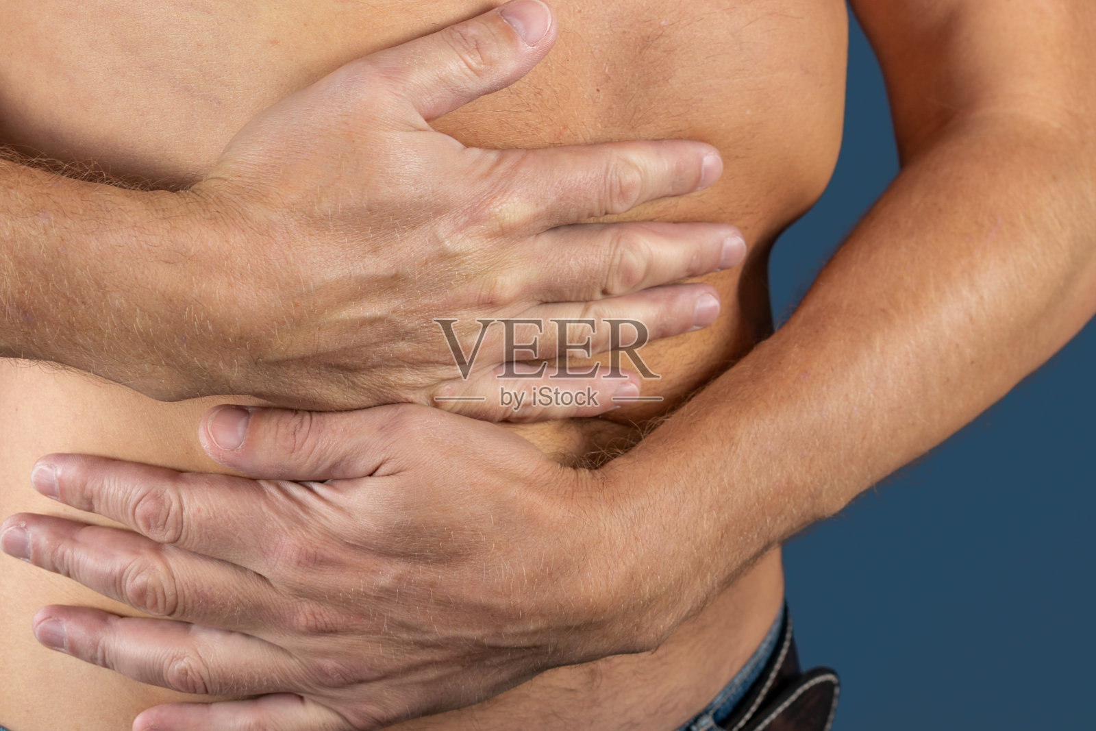 痛苦的人在他的身边。蓝色背景。胃，肝，胰腺，肾照片摄影图片