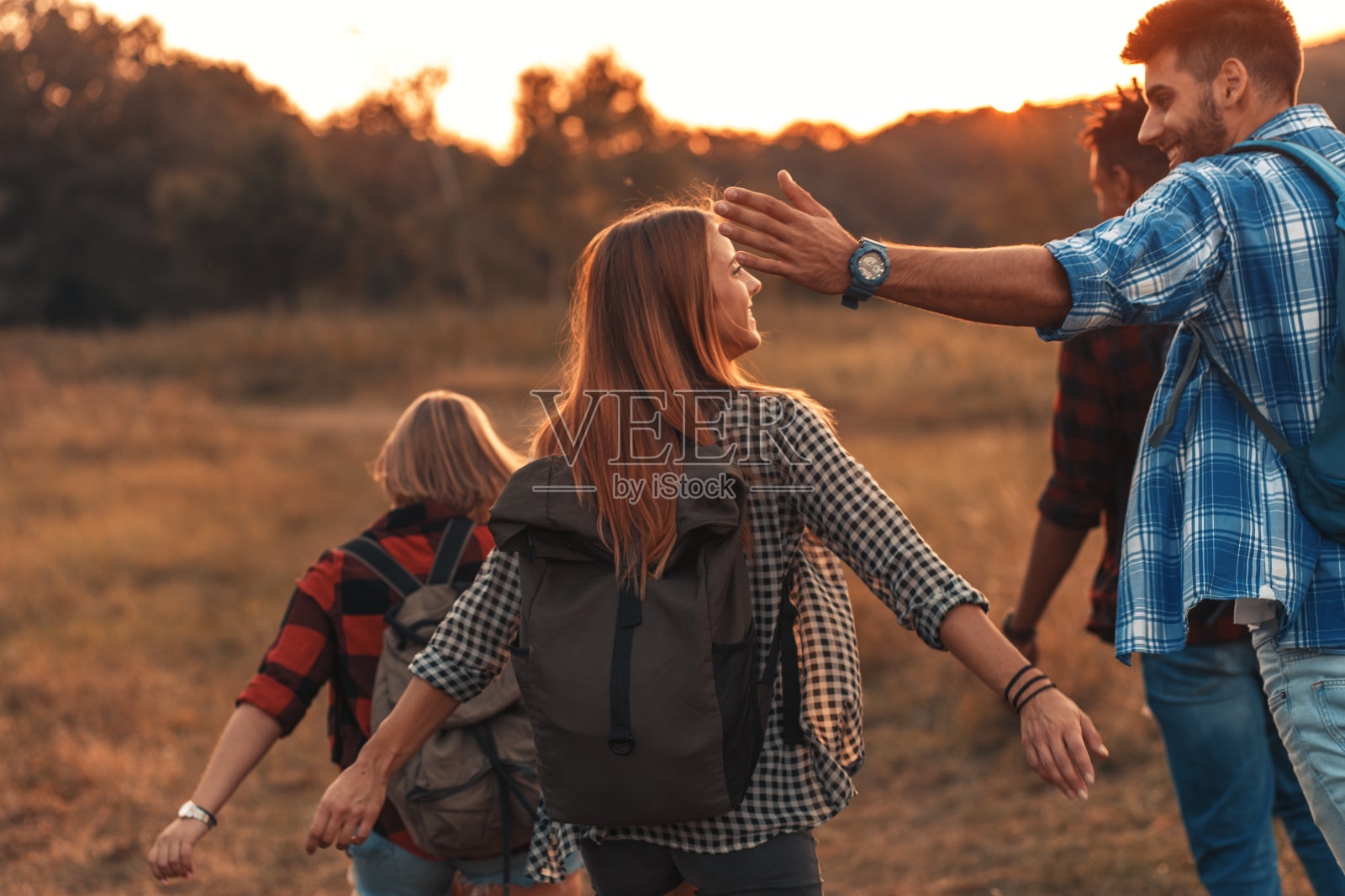 一组四个朋友徒步穿越乡村。照片摄影图片