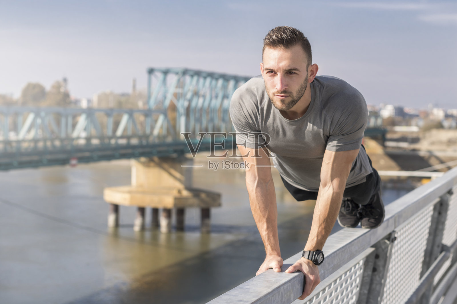 运动。年轻的运动员在桥上做俯卧撑照片摄影图片