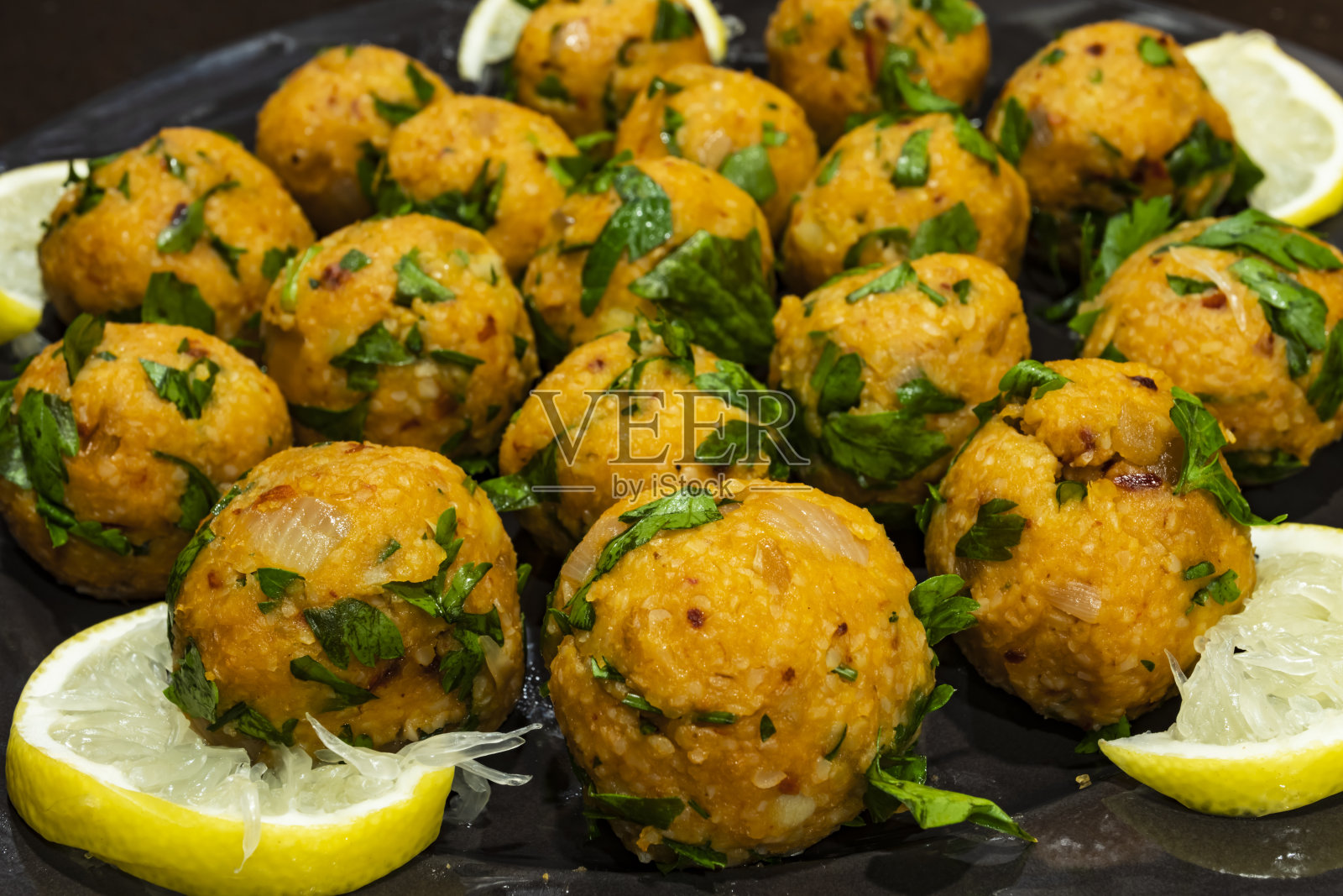 用欧芹和柠檬将土豆饼放入盘中照片摄影图片