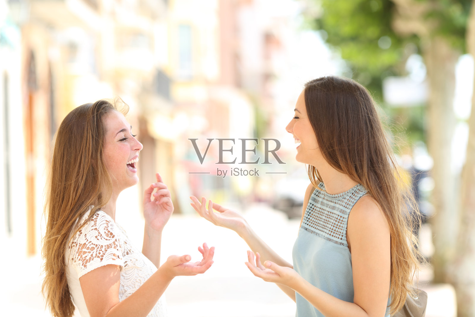 两个快乐的朋友在街上有说有笑照片摄影图片