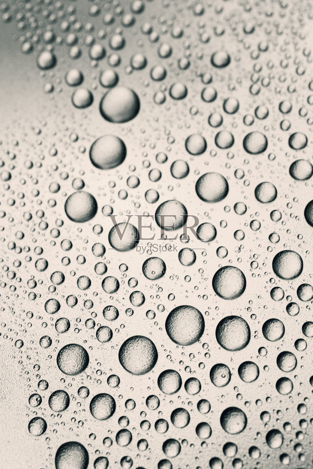 水滴在颗粒状的表面，背景光泽照片摄影图片