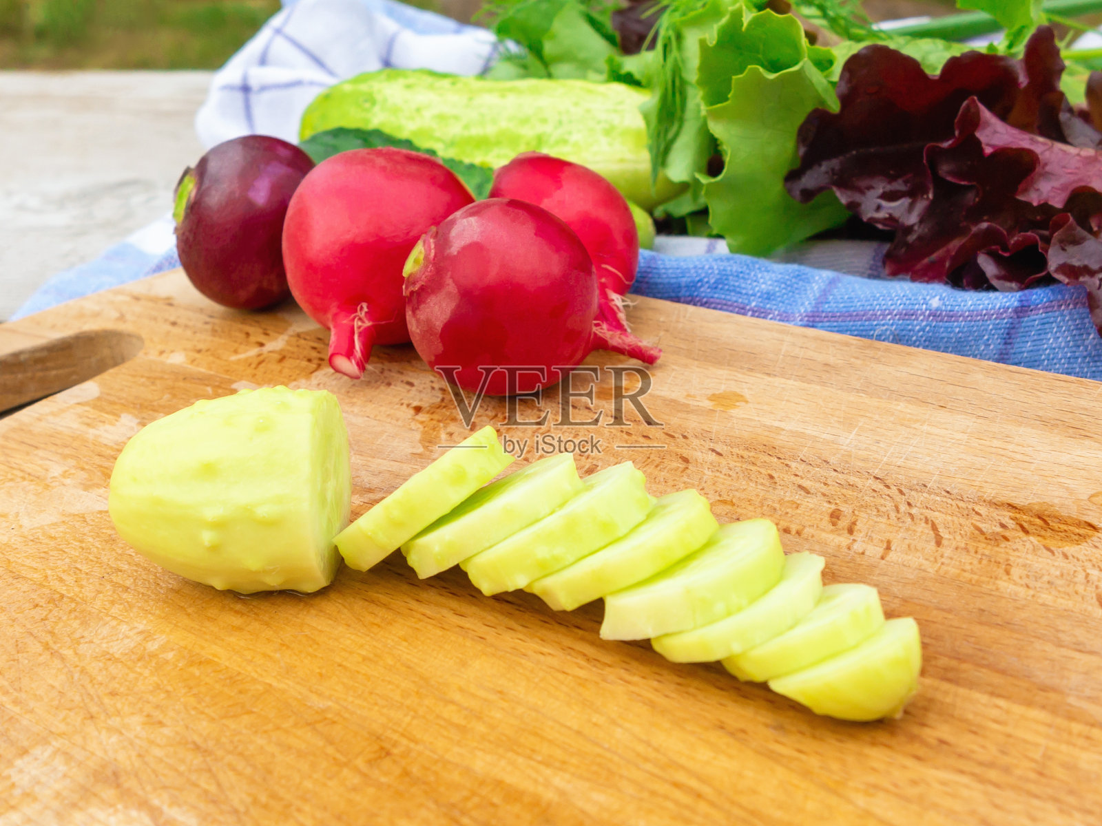 烹饪夏季蔬菜沙拉。切黄瓜特写照片摄影图片
