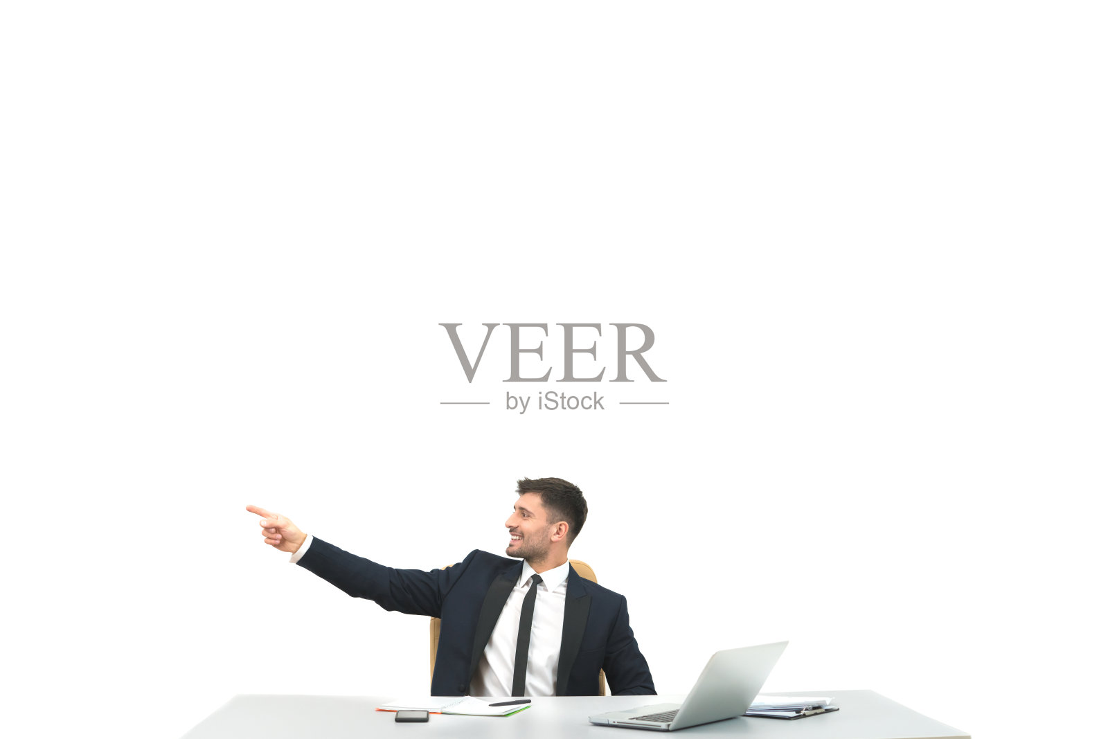 一个快乐的人坐在桌面，在白色的背景上打手势照片摄影图片