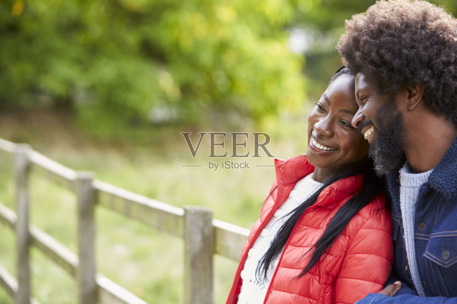 一名黑人成年女子靠在男友的肩膀上，站在乡村里，特写照片摄影图片
