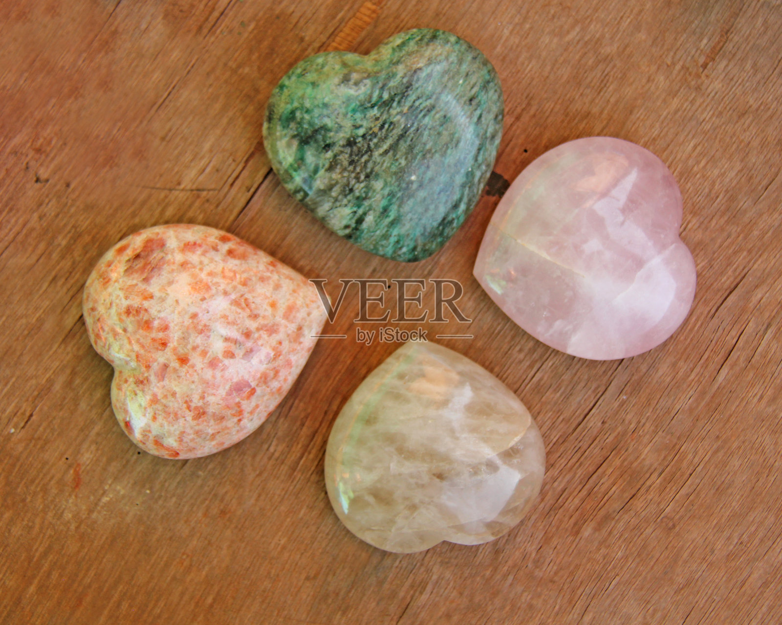 心形的石头躺在棕色的背景上。心脏由天然石英石、菱铁矿和大理石制成。喜欢护身符，水疗，禅宗或瑜伽照片摄影图片