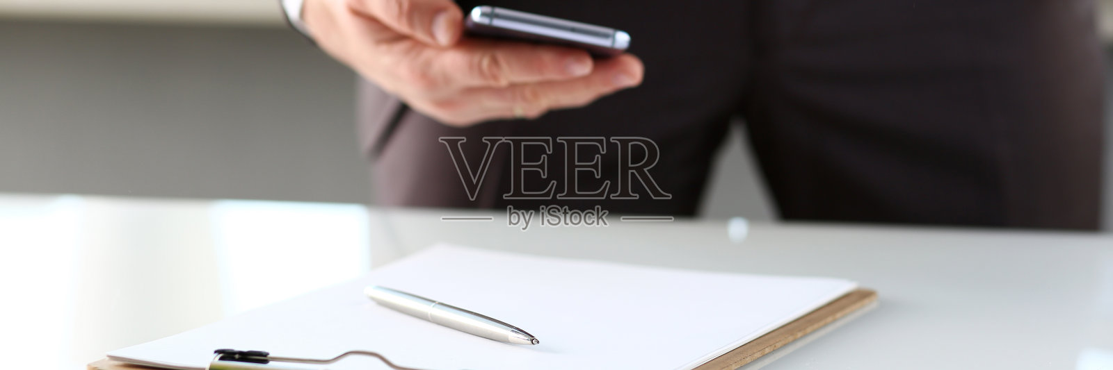 银笔被夹在桌上的便签纸上照片摄影图片