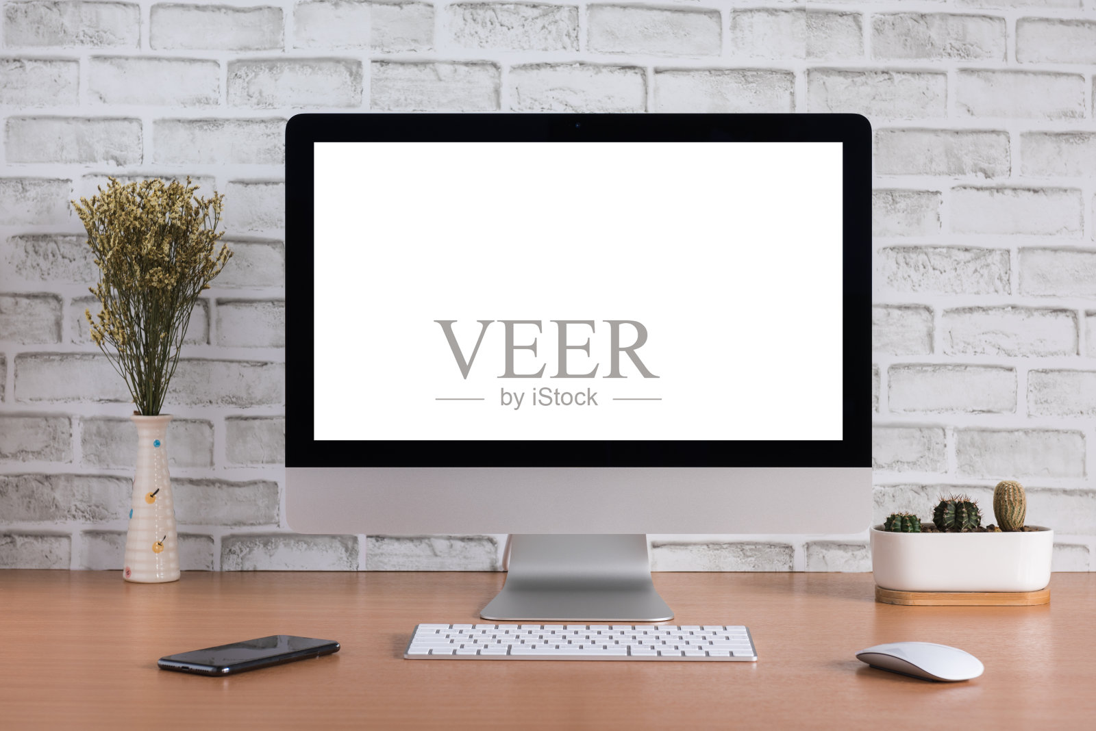 白砖背景上的干花、iPhone X和仙人掌花瓶，全是一台电脑的空白屏幕照片摄影图片