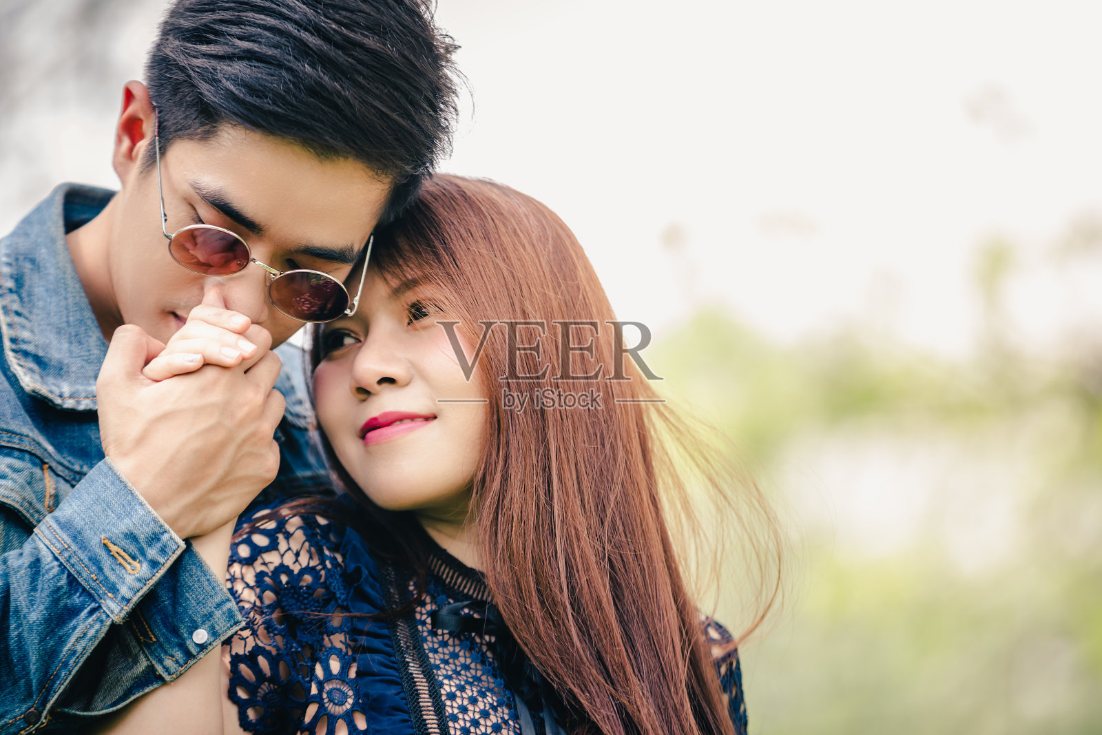 特写手亚洲夫妇在公园树下拥抱爱照片摄影图片