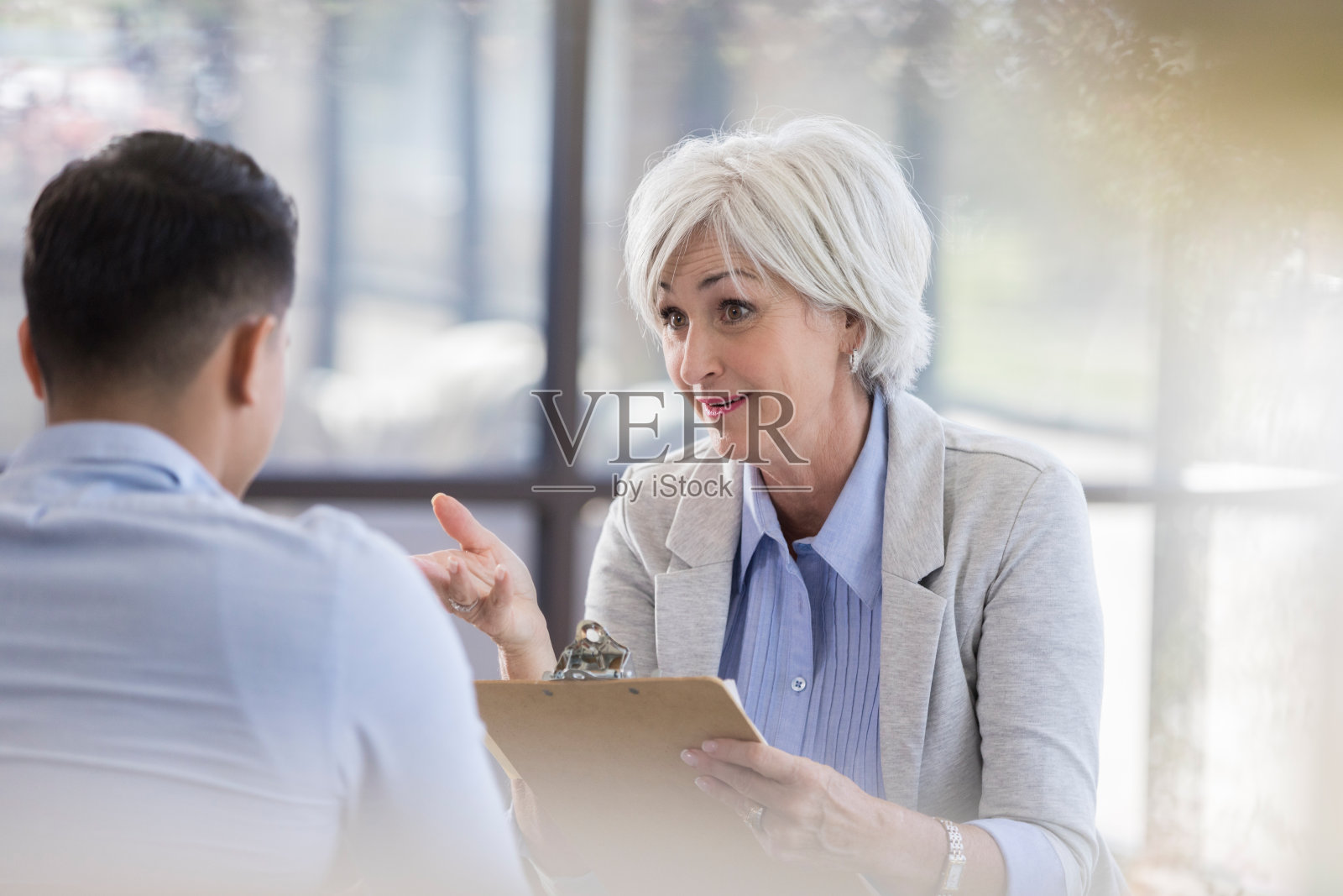 一位高级顾问正在和一位年轻男性谈话并做手势照片摄影图片