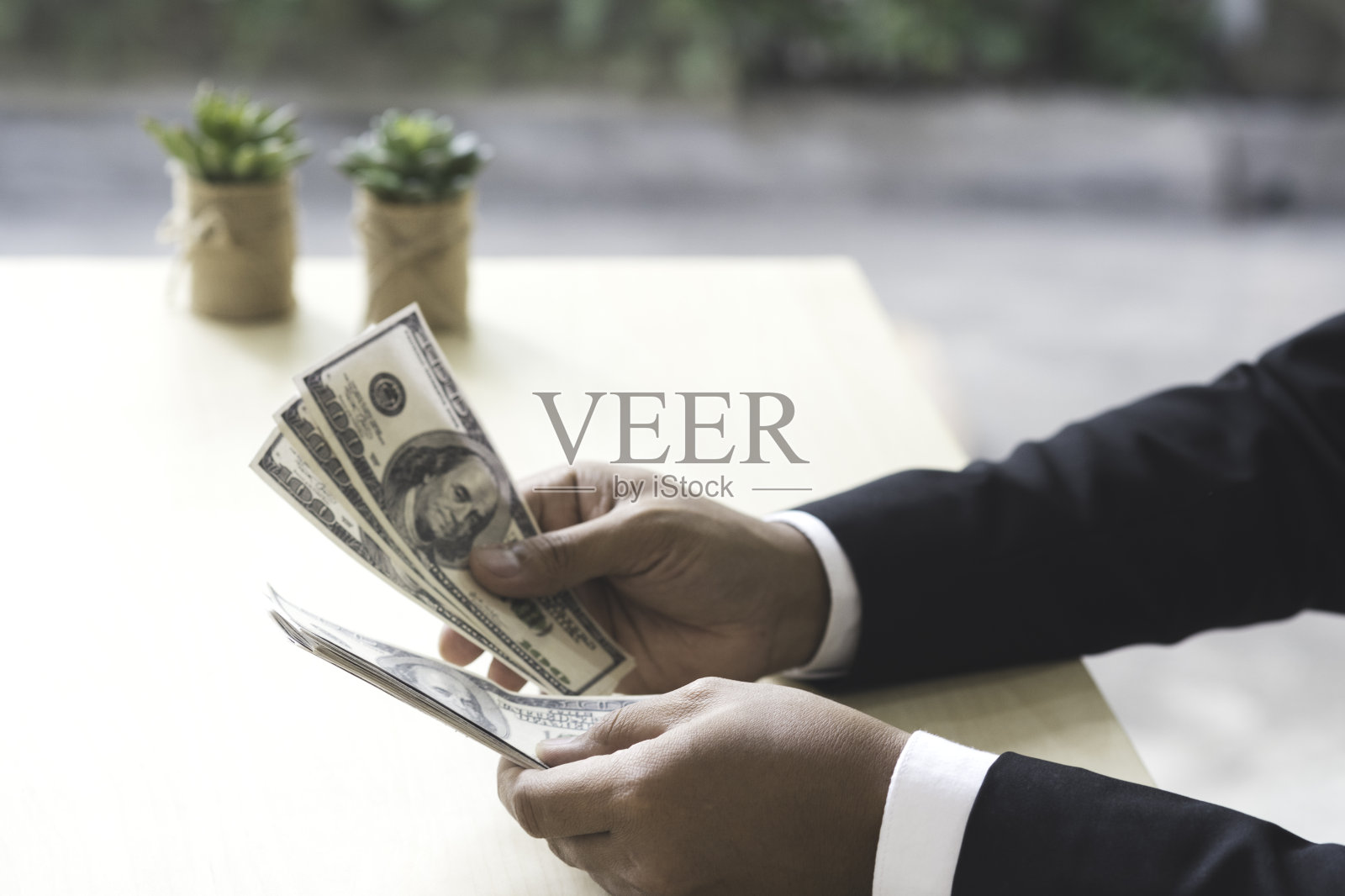 快乐成功的商人手里拿着美钞。照片摄影图片