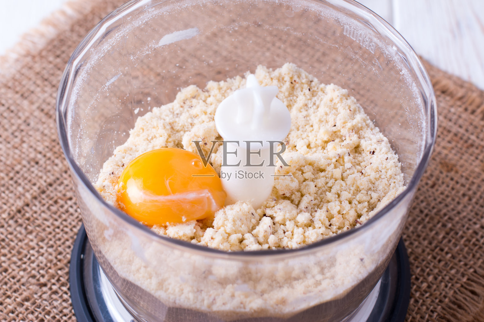 用食品加工机将黄油和鸡蛋放入碗中搅拌照片摄影图片