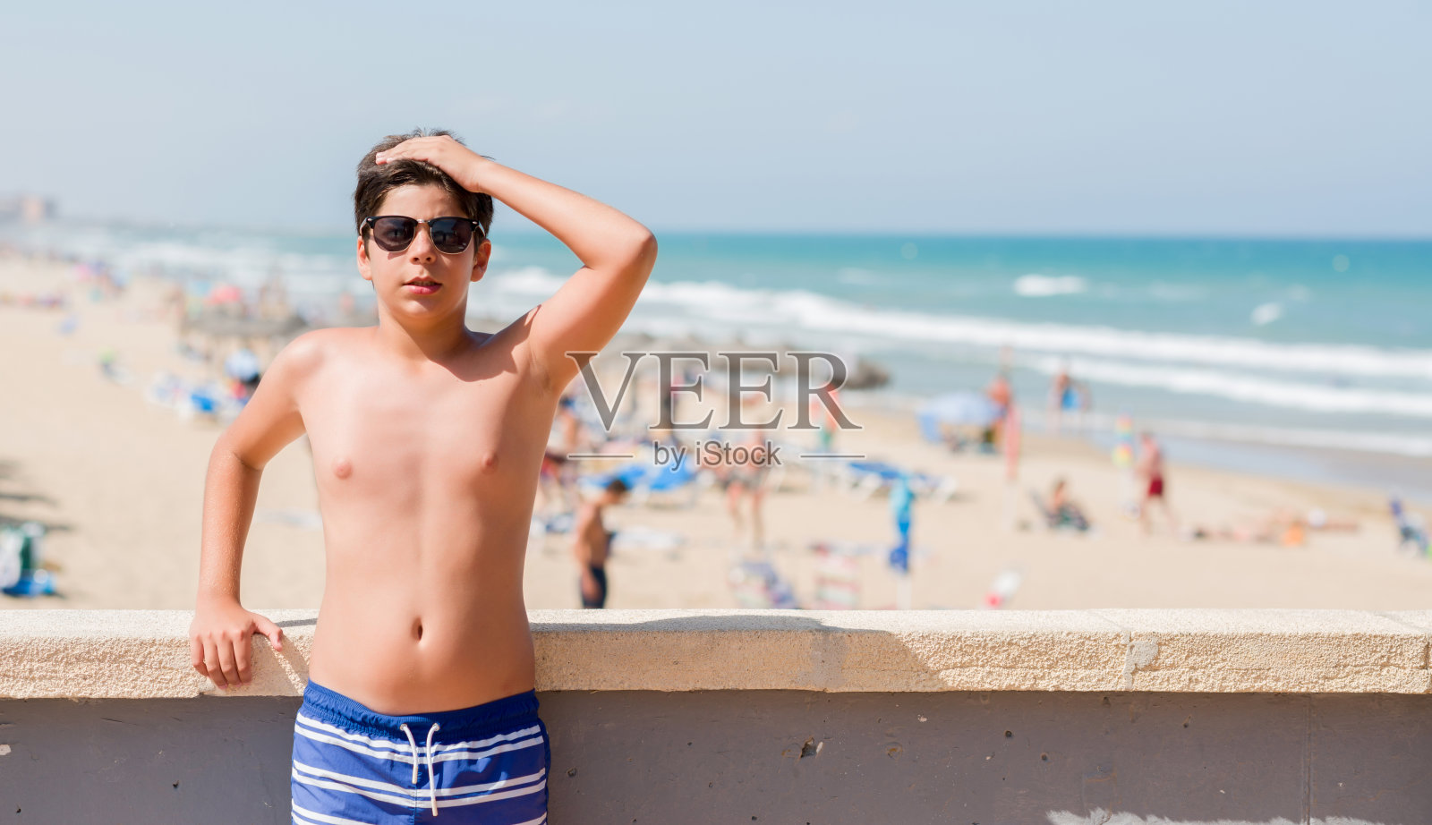 在海滩度假的儿童，手捂头，感到压力、震惊和羞愧照片摄影图片