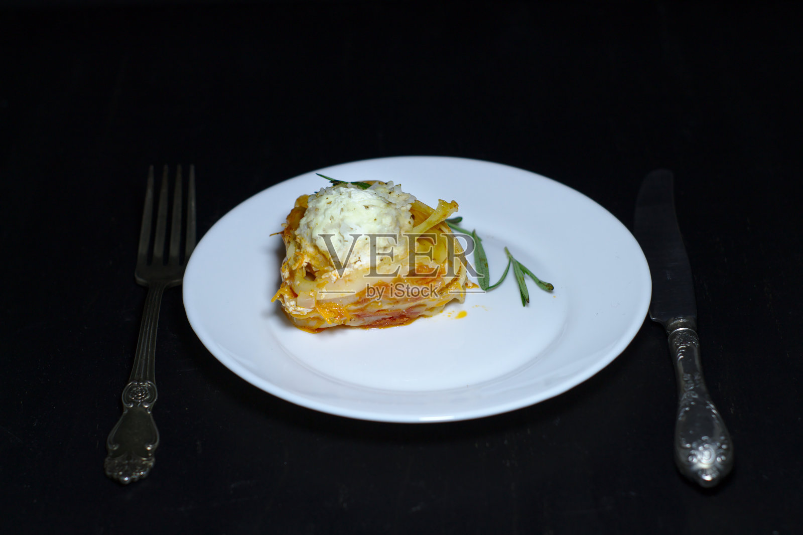 黑桌子上放着鸡肉丸和酸奶油酱的意大利面窝照片摄影图片