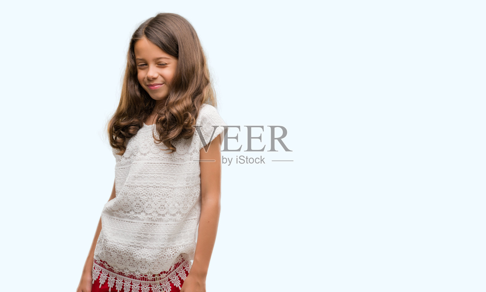 黑发的西班牙裔女孩眨着眼睛看着镜头，性感的表情，快乐的脸。照片摄影图片