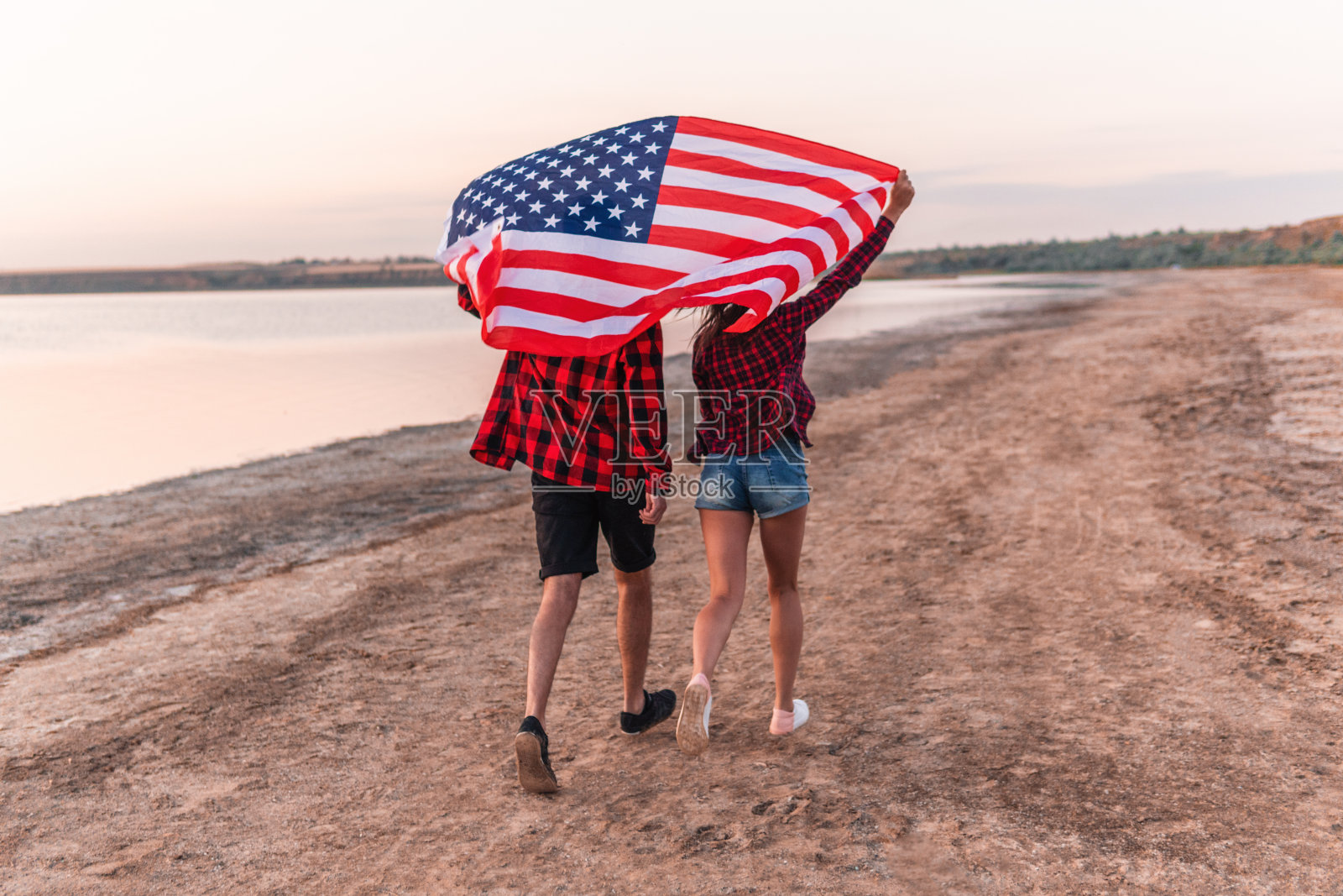 一对年轻夫妇在海滩上散步照片摄影图片