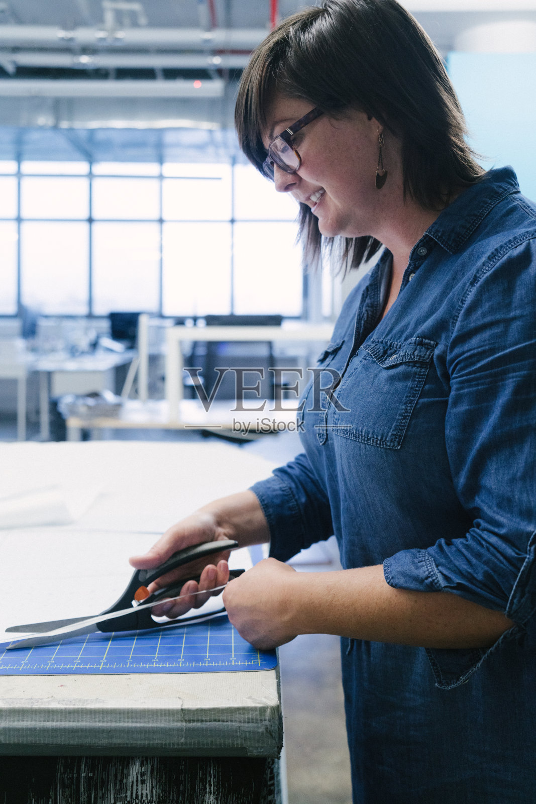 时装设计师在她的工作室工作。照片摄影图片