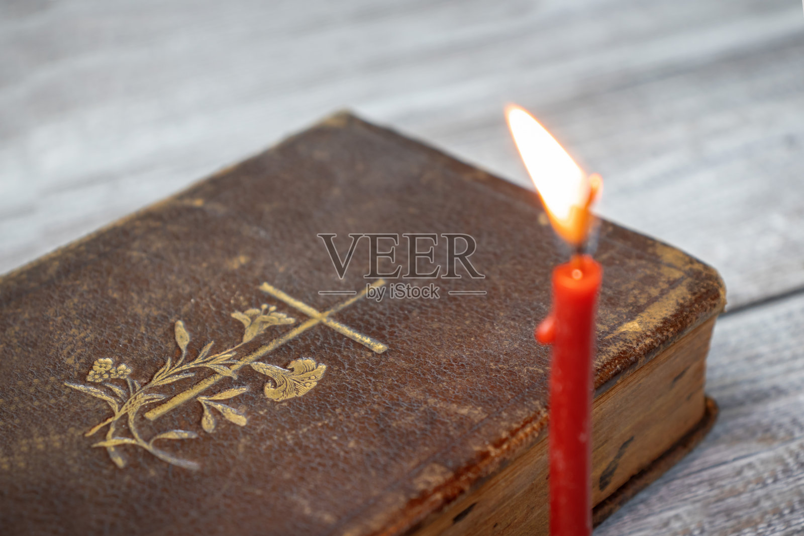 天主教圣经和红色教堂燃烧的蜡烛木制背景照片摄影图片