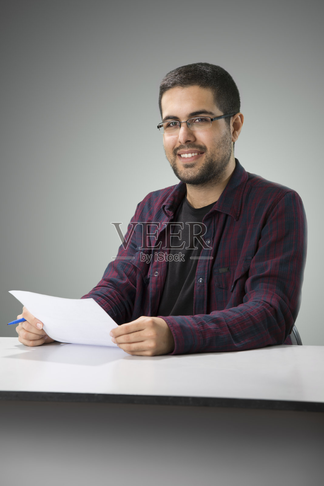 坐在桌子旁的年轻男子照片摄影图片