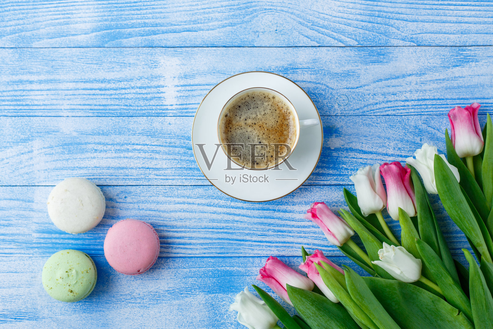 蓝色木质背景上的郁金香和杏仁饼干照片摄影图片