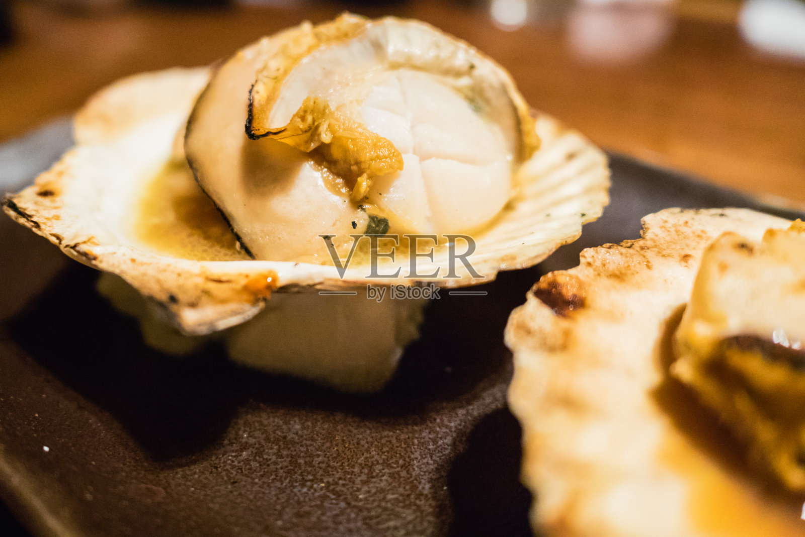 日本北海道札幌市的一种烤扇贝，日语叫“Hotate”，用贝壳裹着吃，加酱油。照片摄影图片