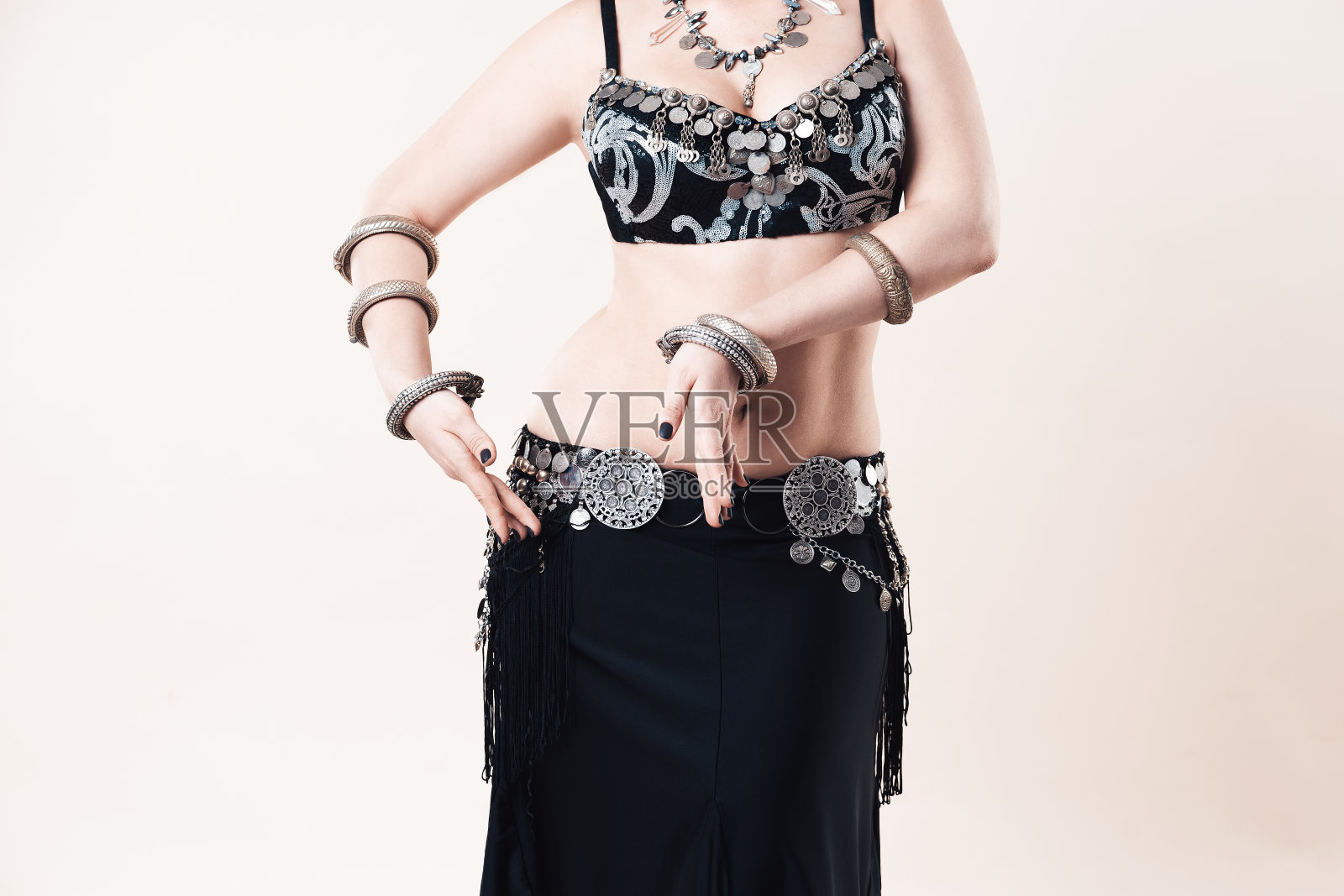 妇女在米色背景下穿着民族服装表演肚皮舞照片摄影图片