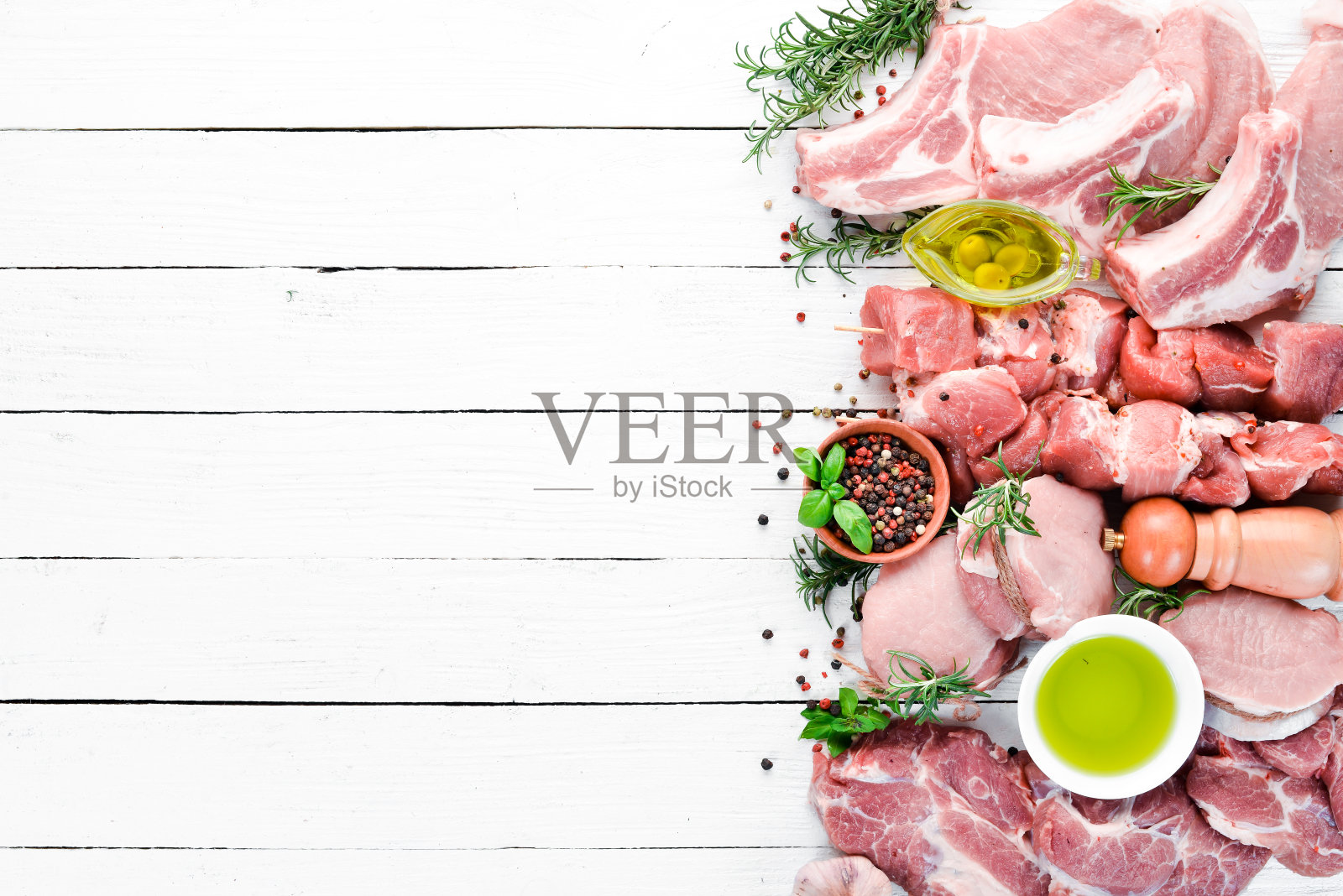 烧烤用的生肉。肉与香料和香草。在白色的木制背景上。前视图。免费空间。照片摄影图片