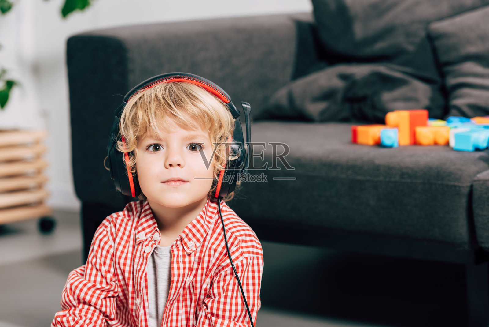 小男孩的近距离肖像听音乐在耳机和看相机照片摄影图片