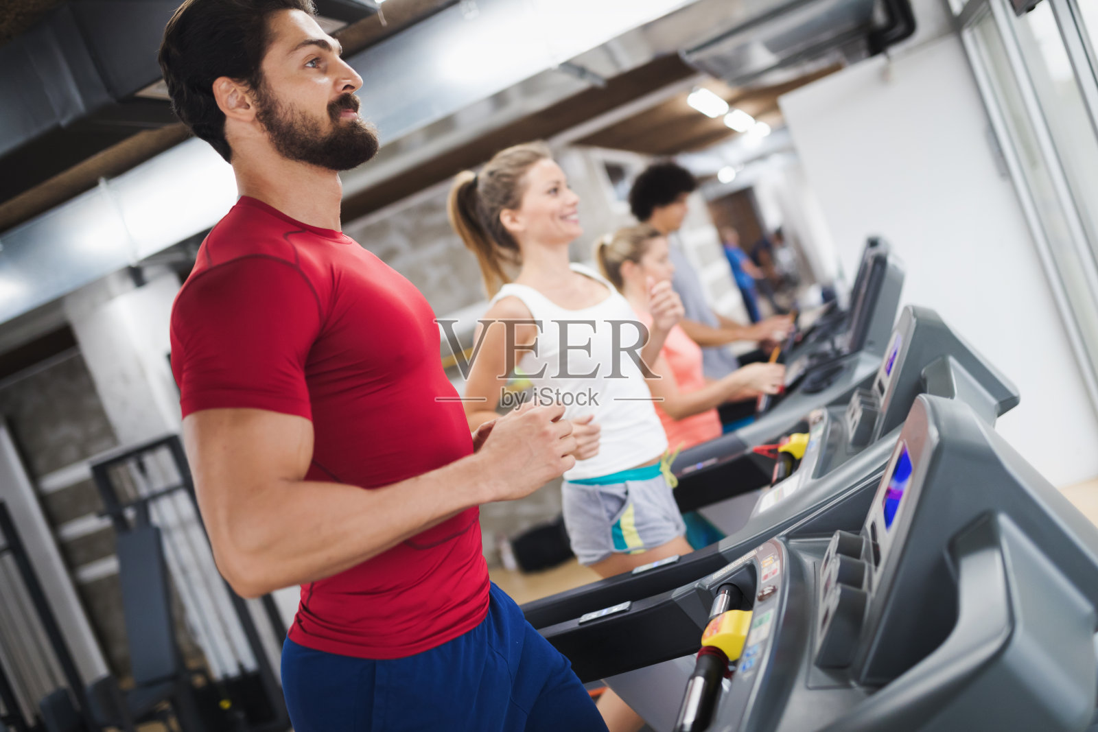 年轻帅气的男人在健身房做有氧运动照片摄影图片