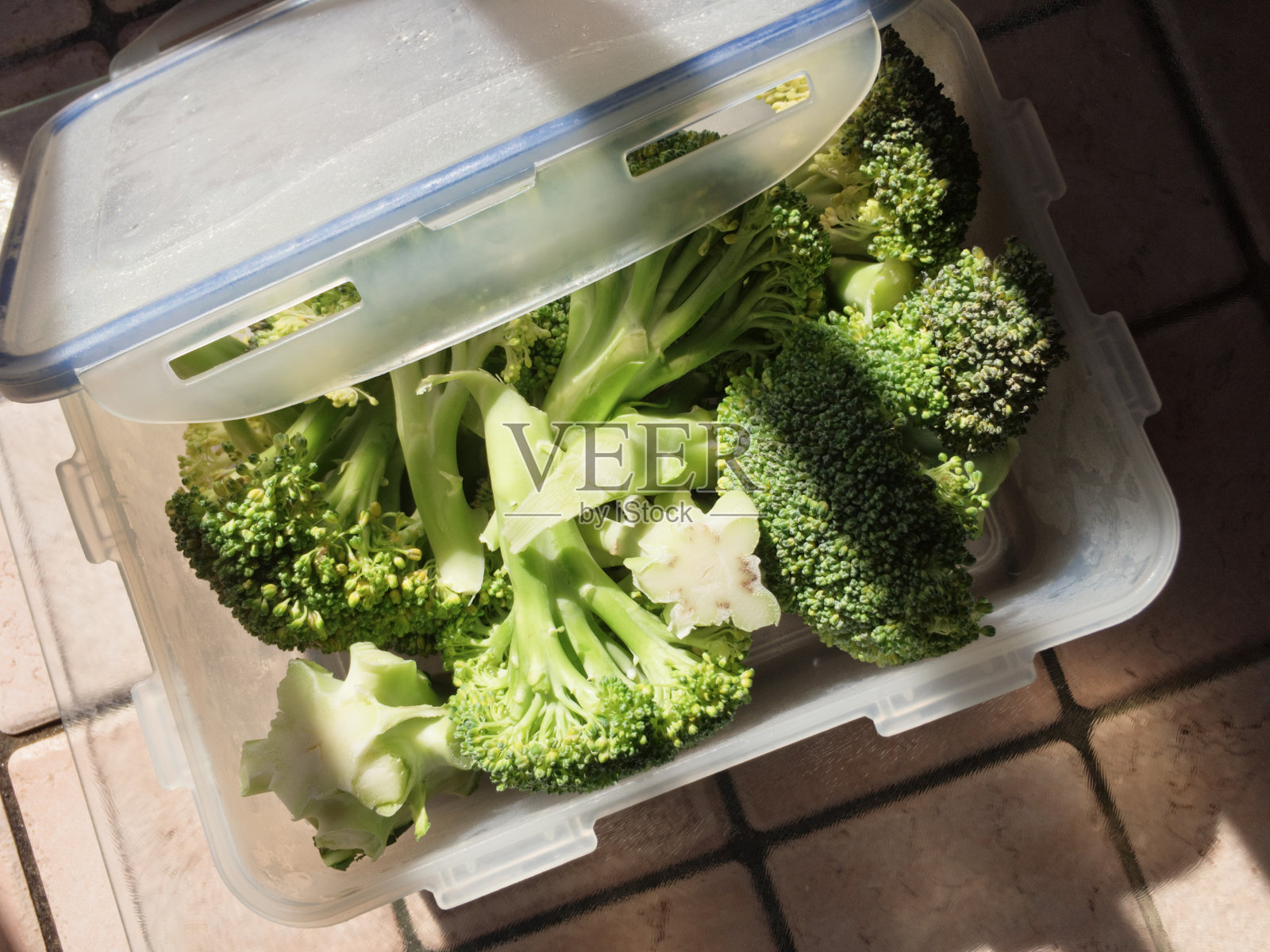 塑料食品容器与菜刀生西兰花照片摄影图片