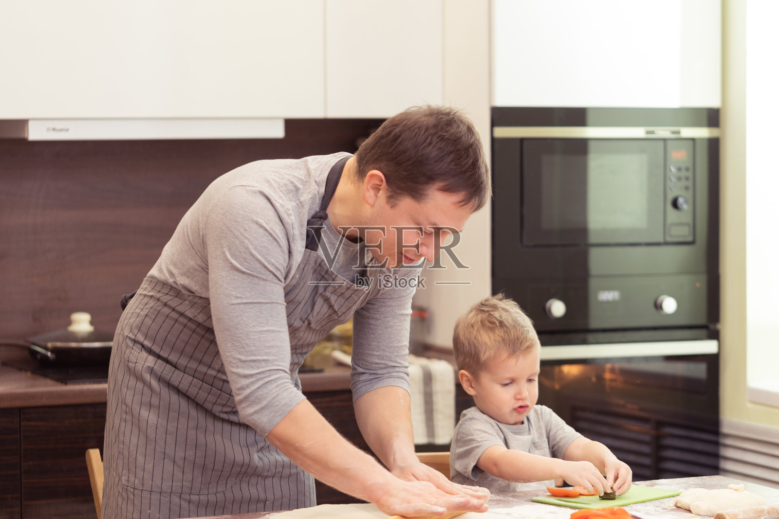 爸爸和儿子在家做披萨照片摄影图片