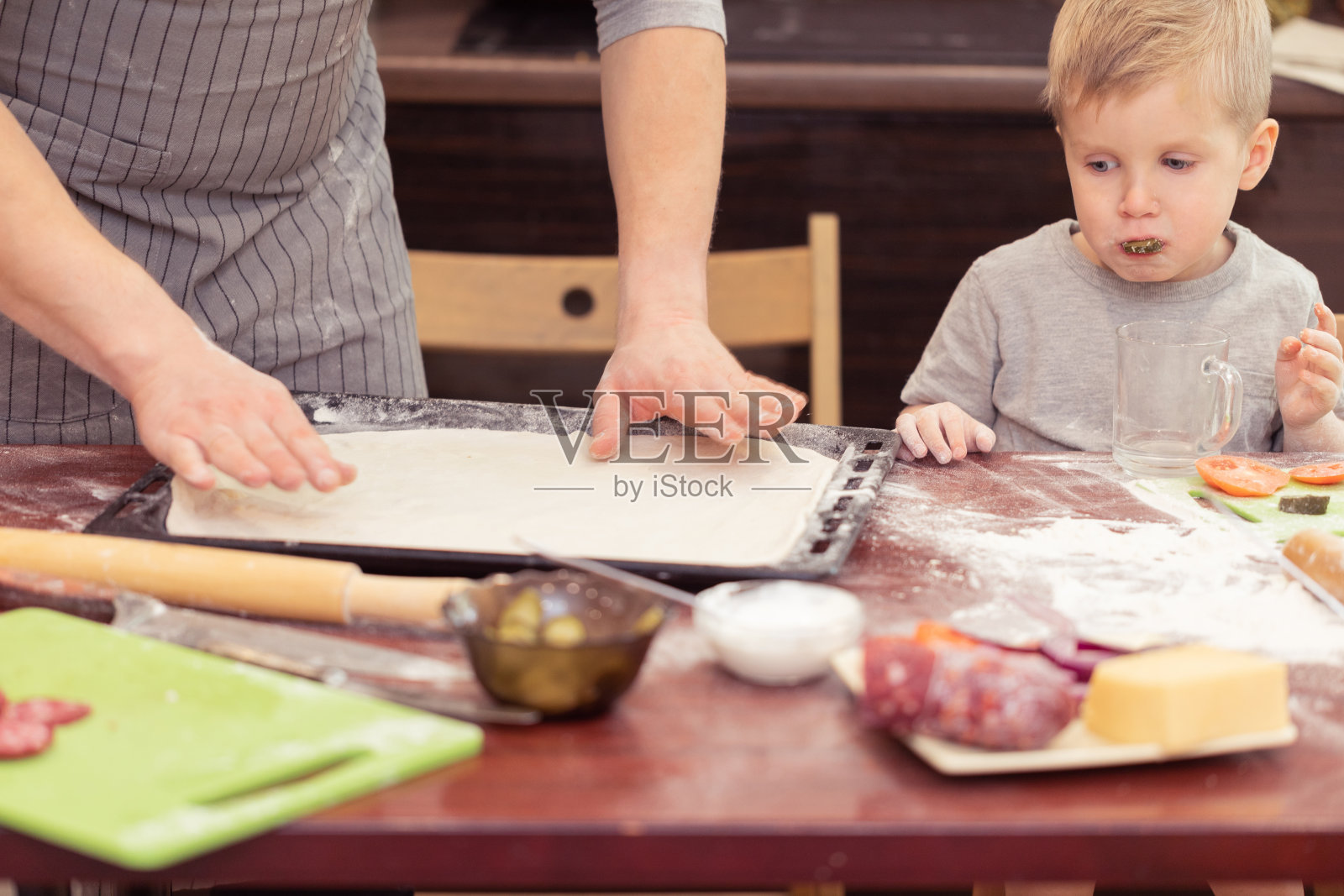 爸爸和儿子在厨房里愉快地做披萨照片摄影图片