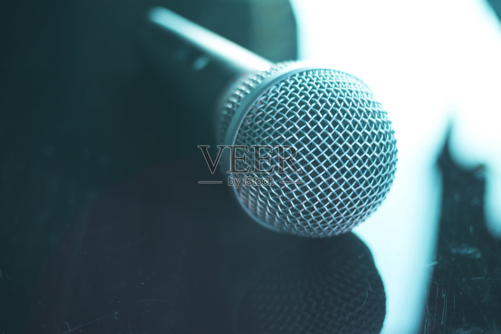 歌手在演唱会舞台上手持麦克风进行演唱和演示或画外音。照片摄影图片