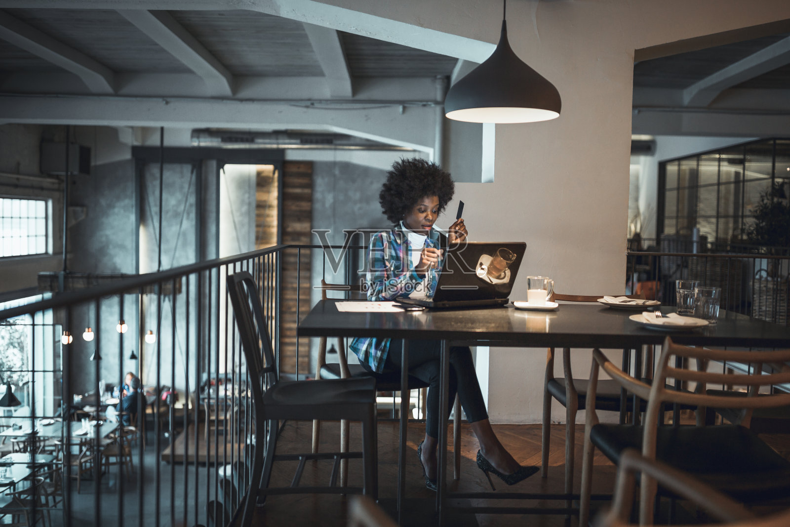 普通女人，非裔美国人，在网上购物，在咖啡馆用信用卡购物。照片摄影图片