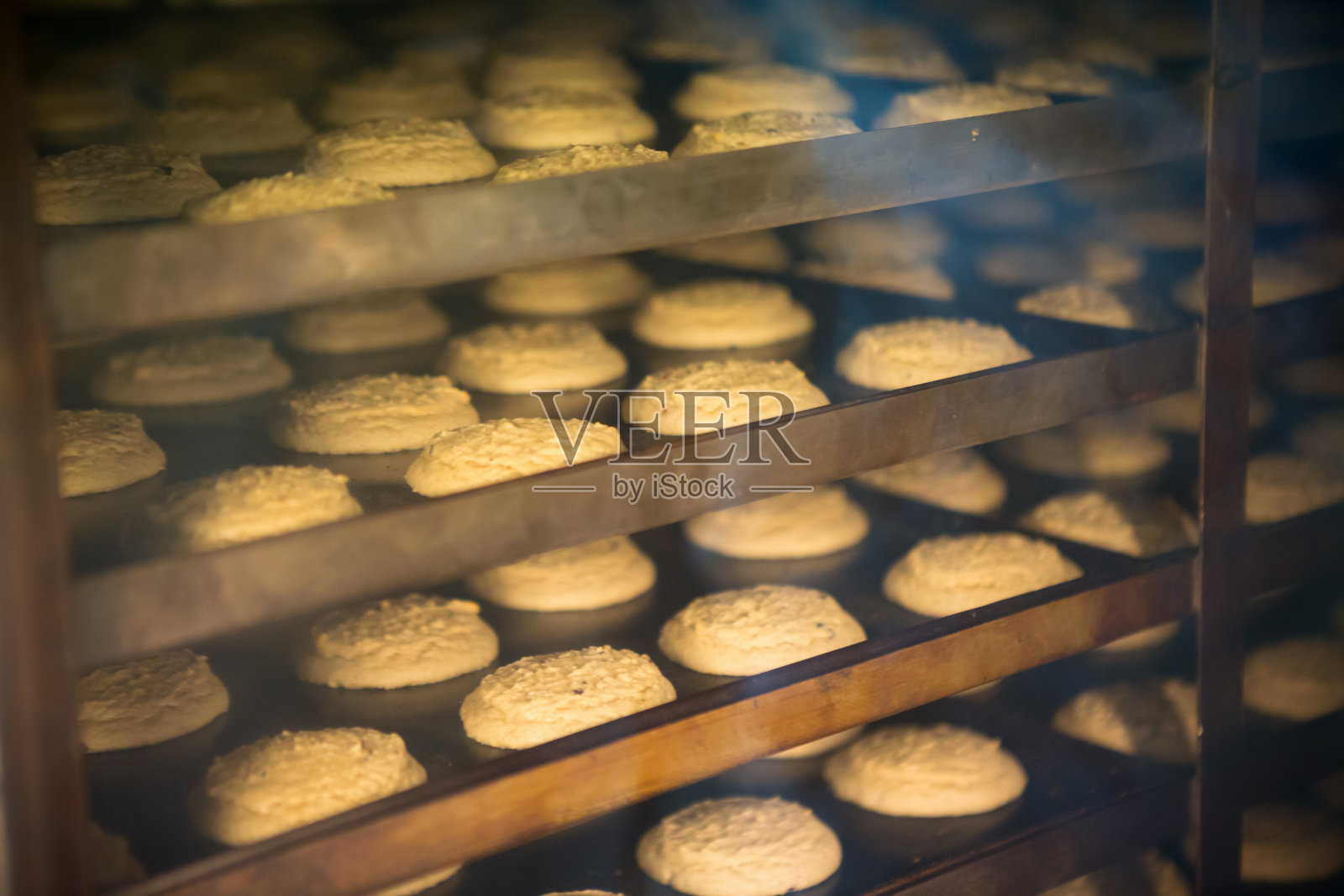 现代面包店在糖果工厂。烤箱里的饼干照片摄影图片