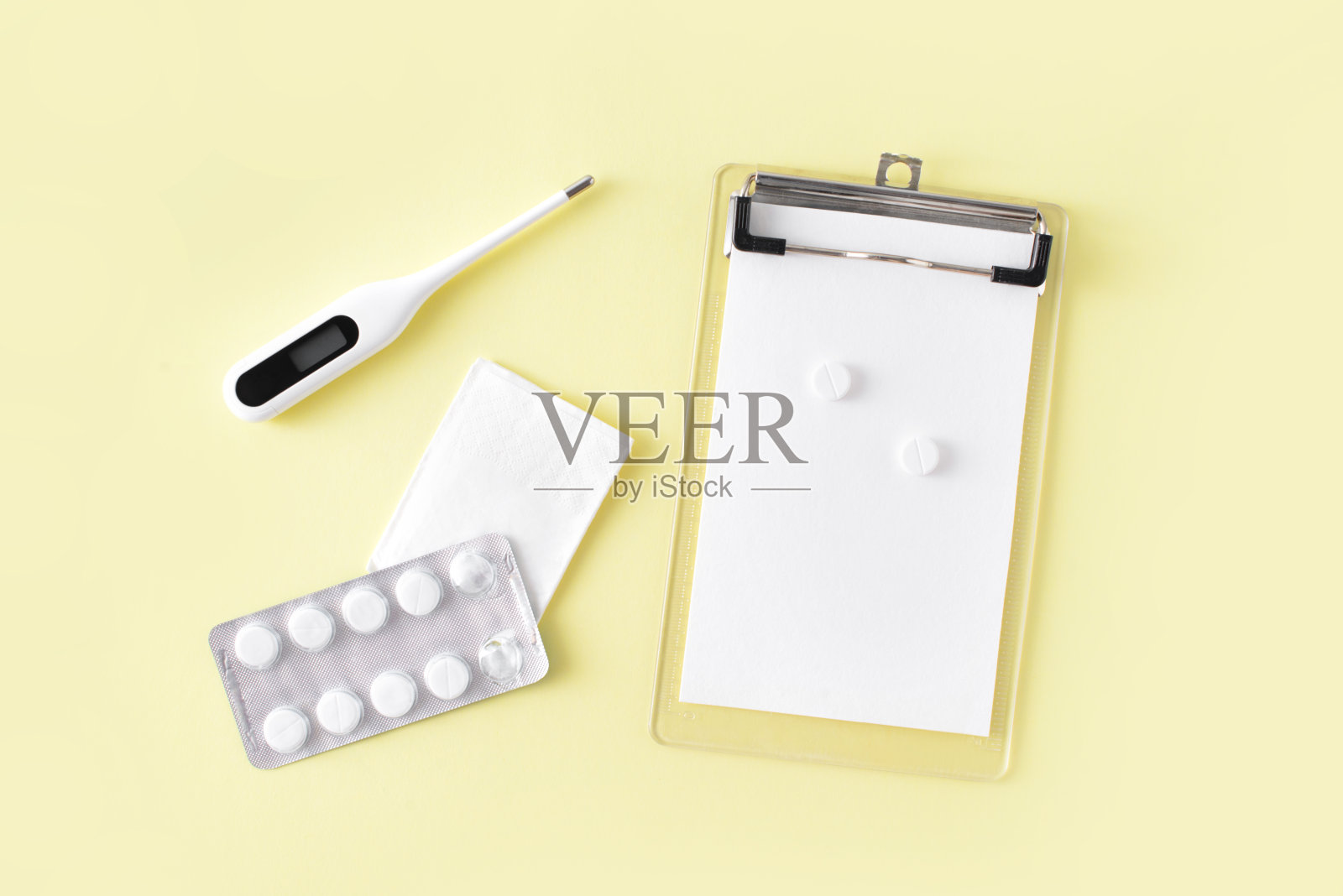 药片，体温计和食谱笔记在黄色背景上。感冒和流感治疗套装。平躺，俯视图。照片摄影图片