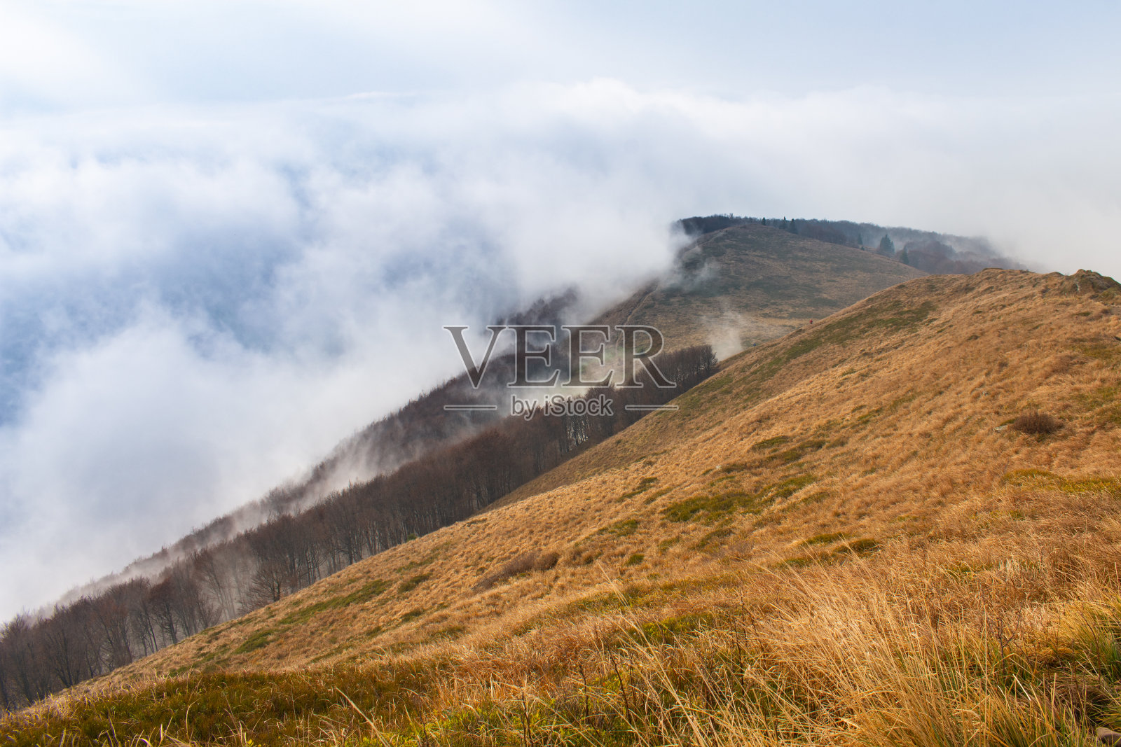 山峰上的云雾很快被风吹走了。照片摄影图片