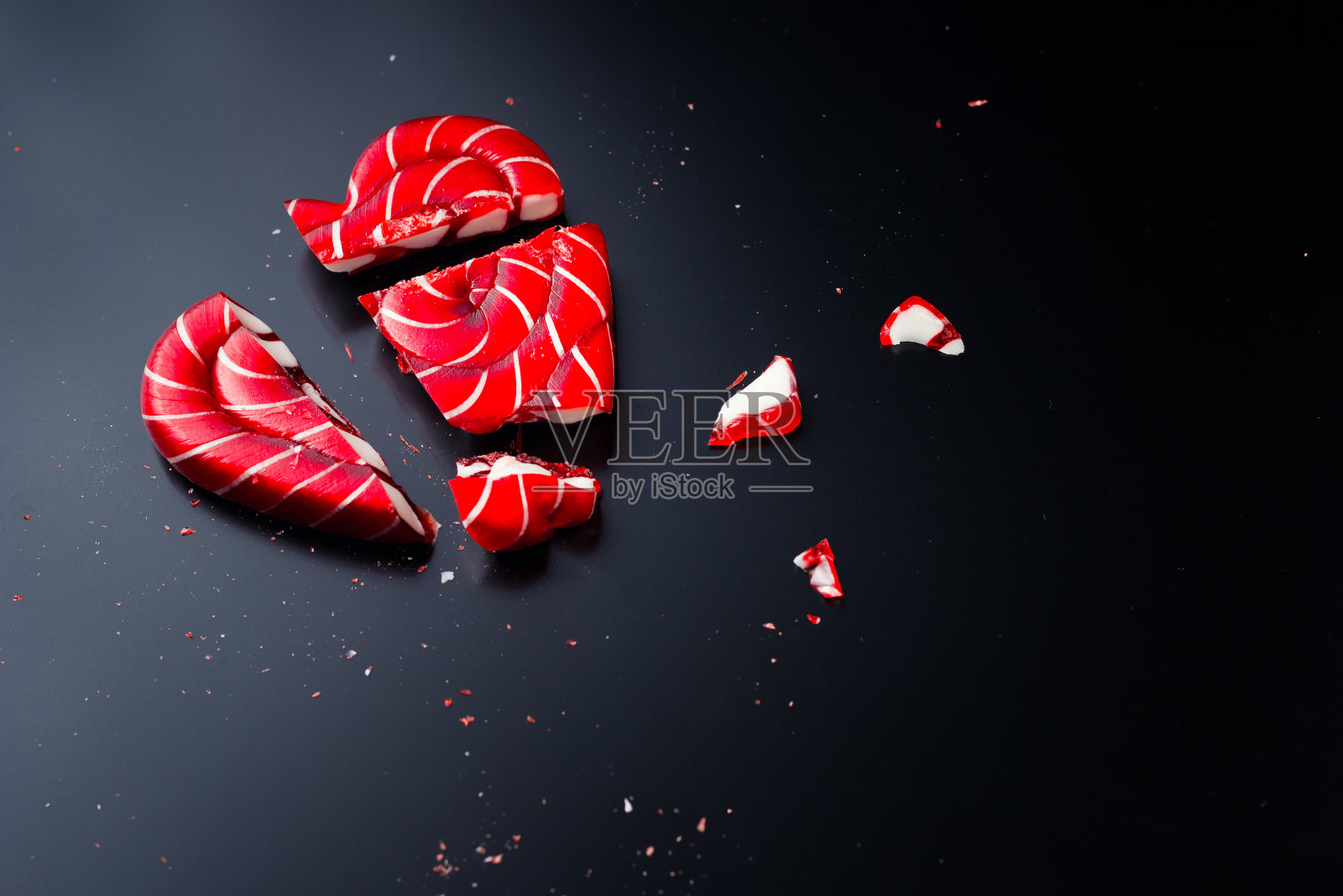 心脏形状的碎棒棒糖，在深色背景和复制空间照片摄影图片