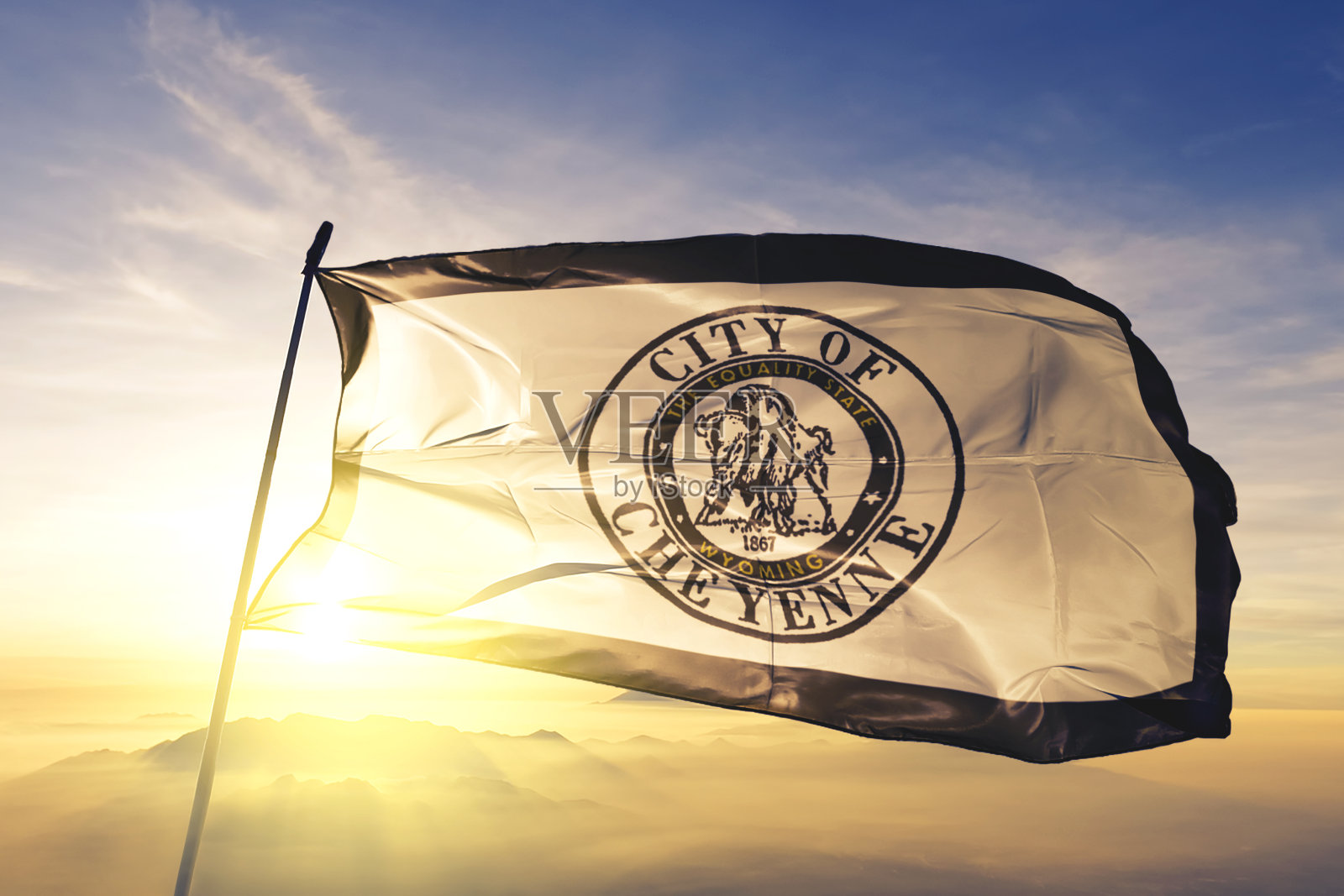 美国怀俄明州首府夏延市的国旗、纺织布、织物在日出的薄雾上摇摆照片摄影图片