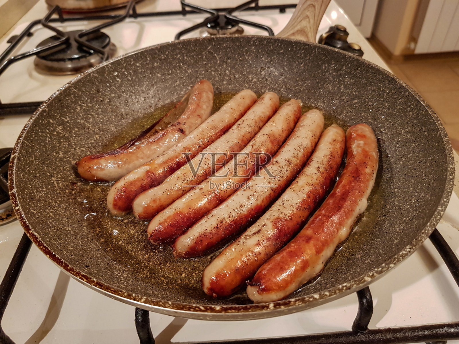 在煎锅里烤香肠照片摄影图片