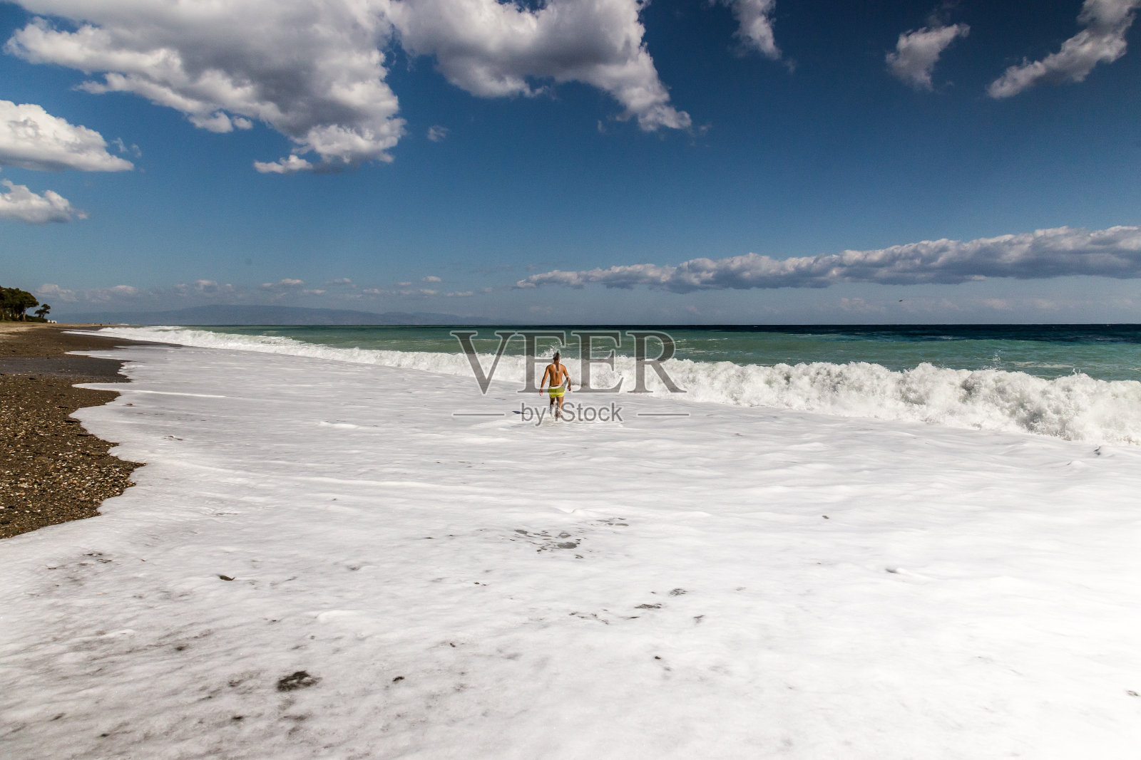 西西里岛陶尔米纳附近，一名男子在享受海浪照片摄影图片
