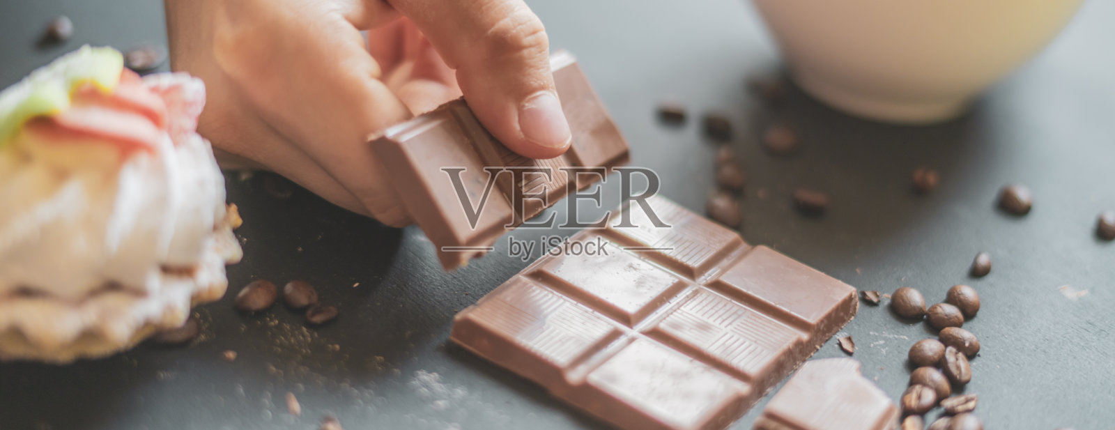 用咖啡杯掰碎一块巧克力照片摄影图片