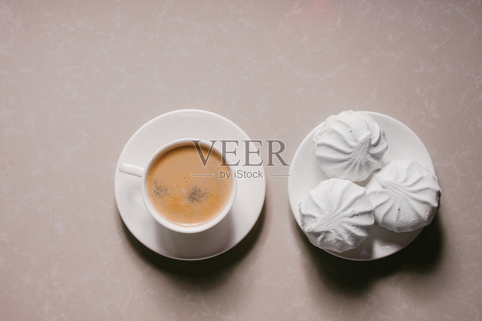 一杯新鲜的咖啡，美式咖啡和三个美味的甜甜点白色棉花糖在碟子上特写。本空间照片摄影图片