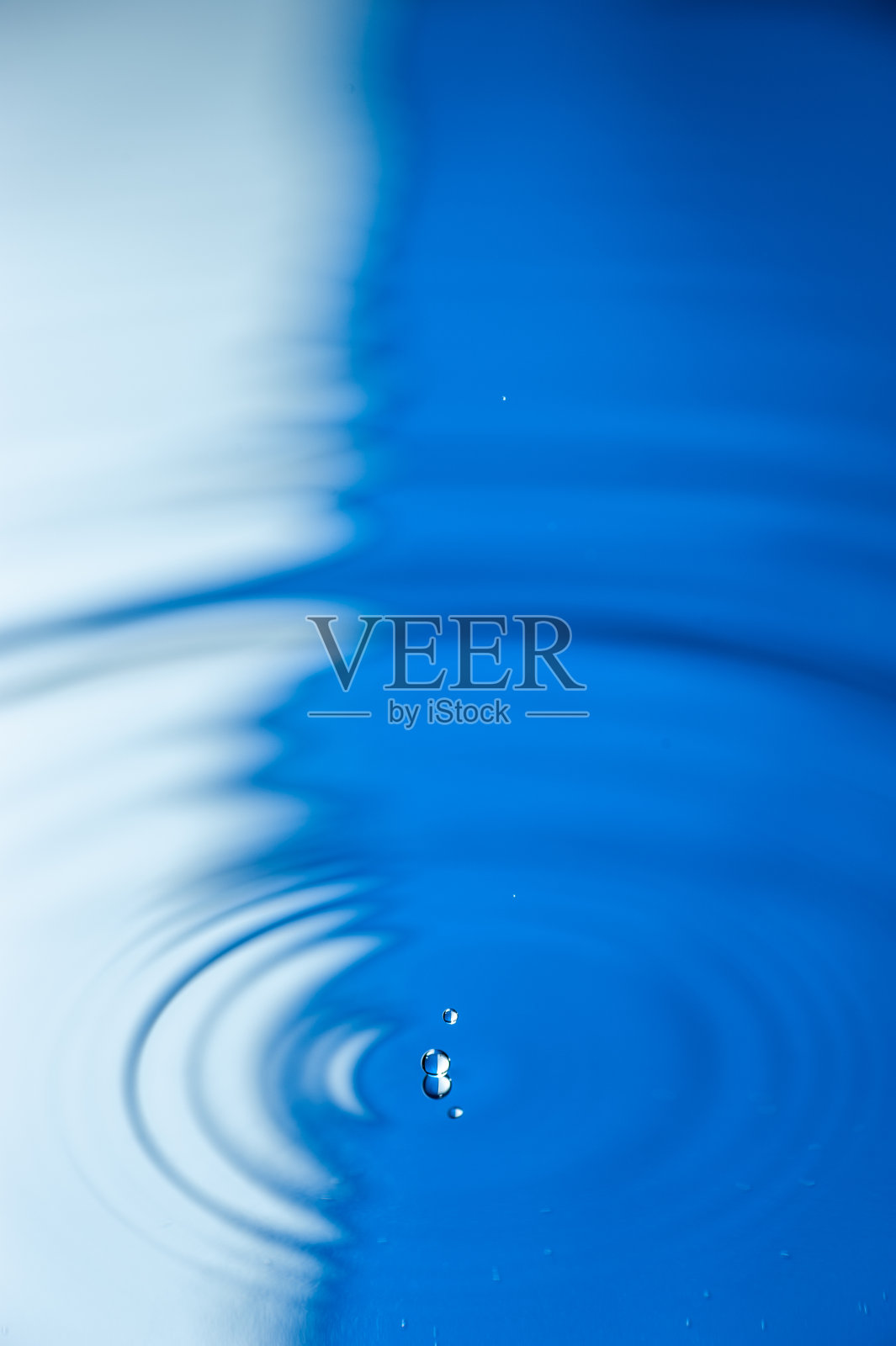 水滴落下来，在平静的水面上激起涟漪照片摄影图片