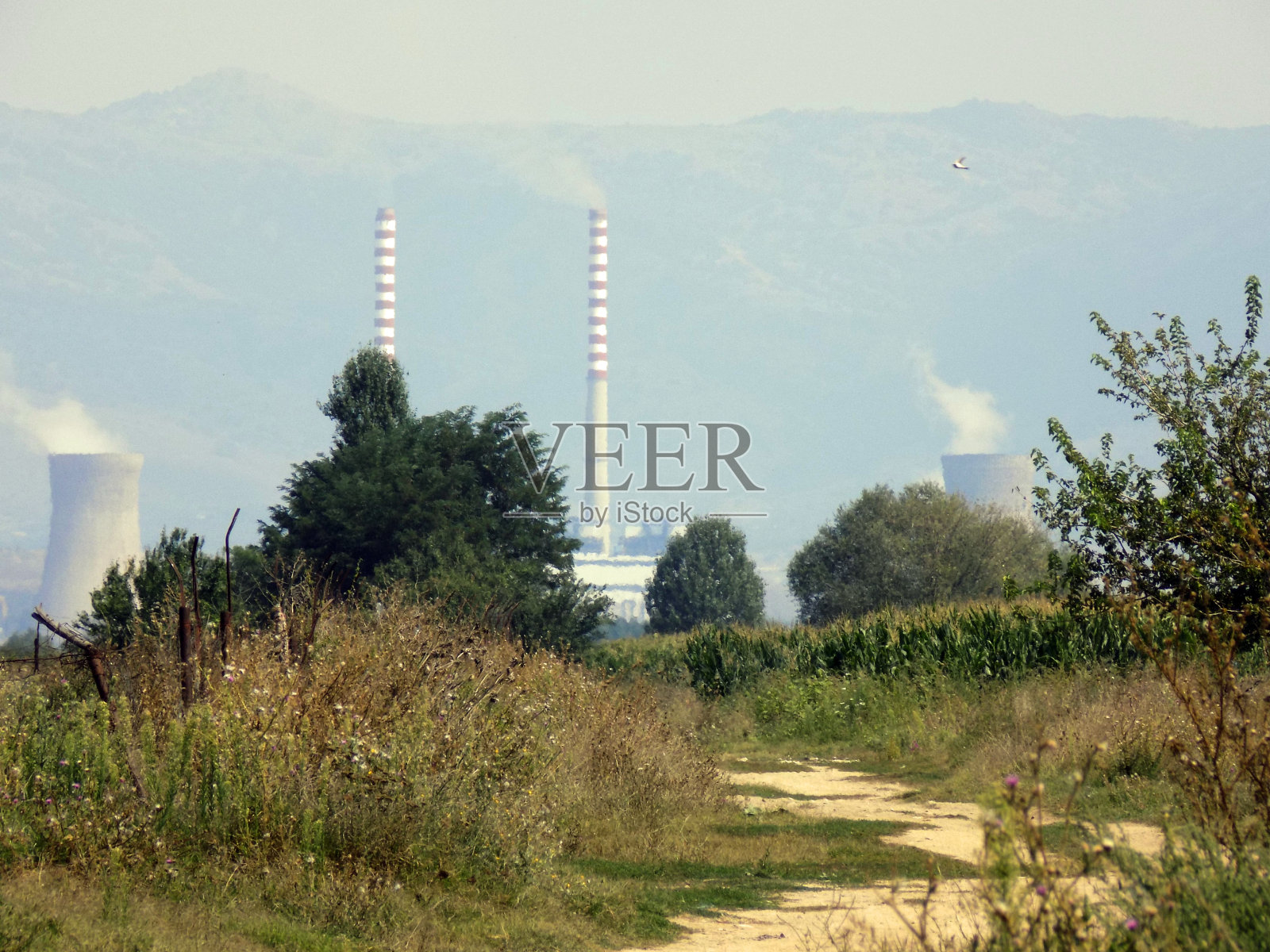 在一个美丽的山谷里，热电厂污染了空气照片摄影图片